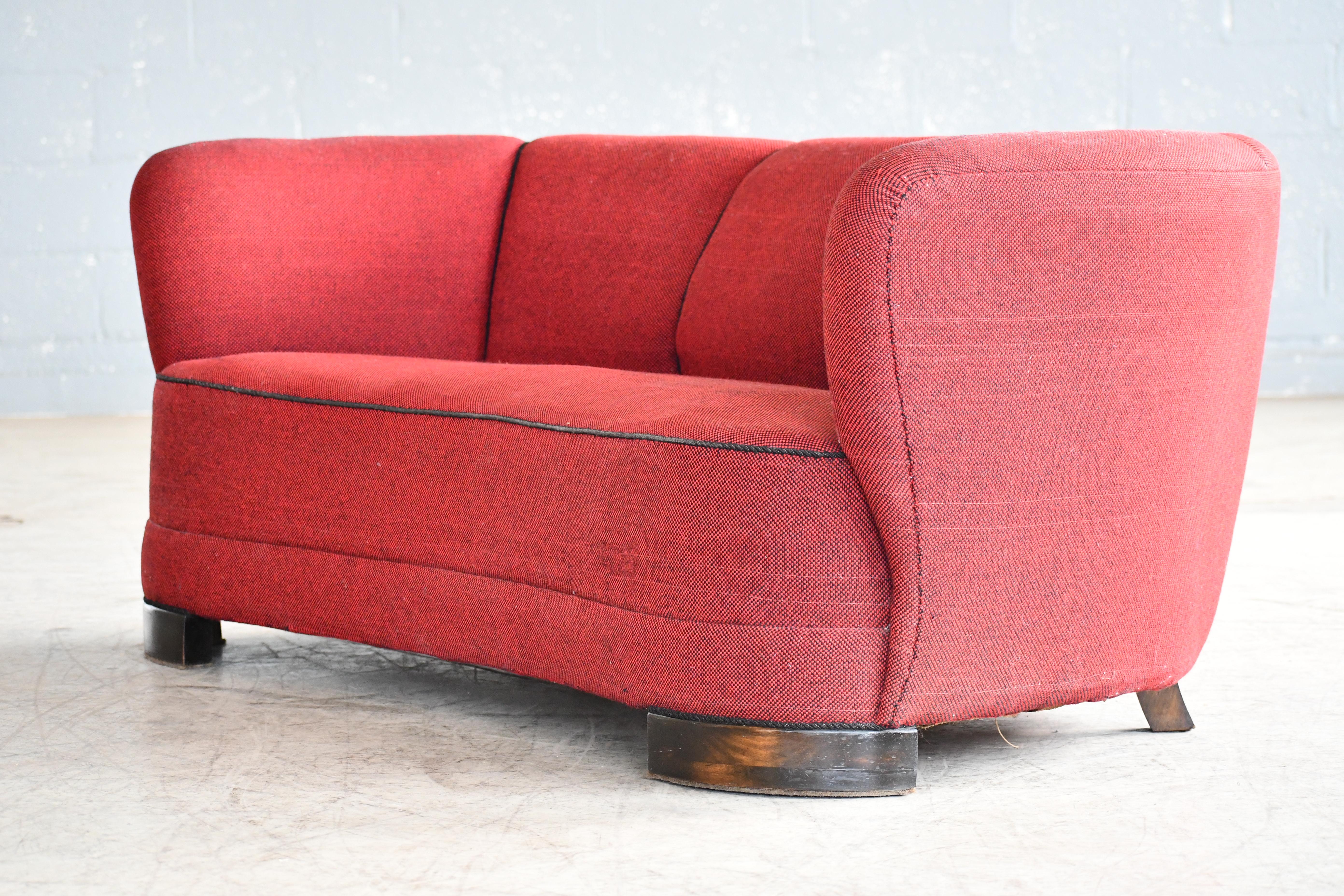 Beautiful and very elegant 1940s curved three-seat sofa in red wool fabric. The sofa has springs in the seat and the backrest and the cushions are nice and firm and the sofa very sturdy. The sofa has been re-upholstered in the past and the wool