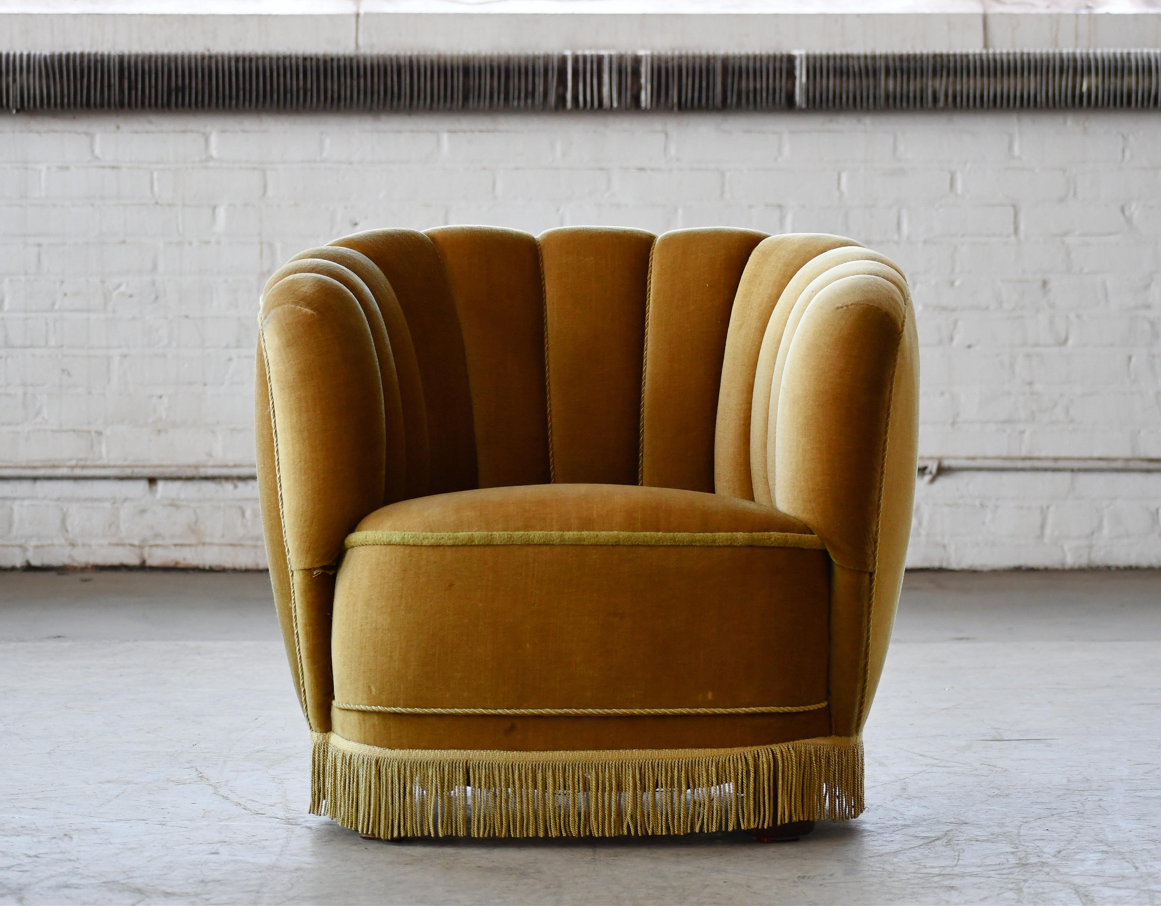 Comfortable, exuberant, and superbly made, this chair perfectly captures the essence of 1940s Danish design coming out of the late Art Deco era and into the early midcentury. The curved backrests and low slung proportions clearly hint at inspiration
