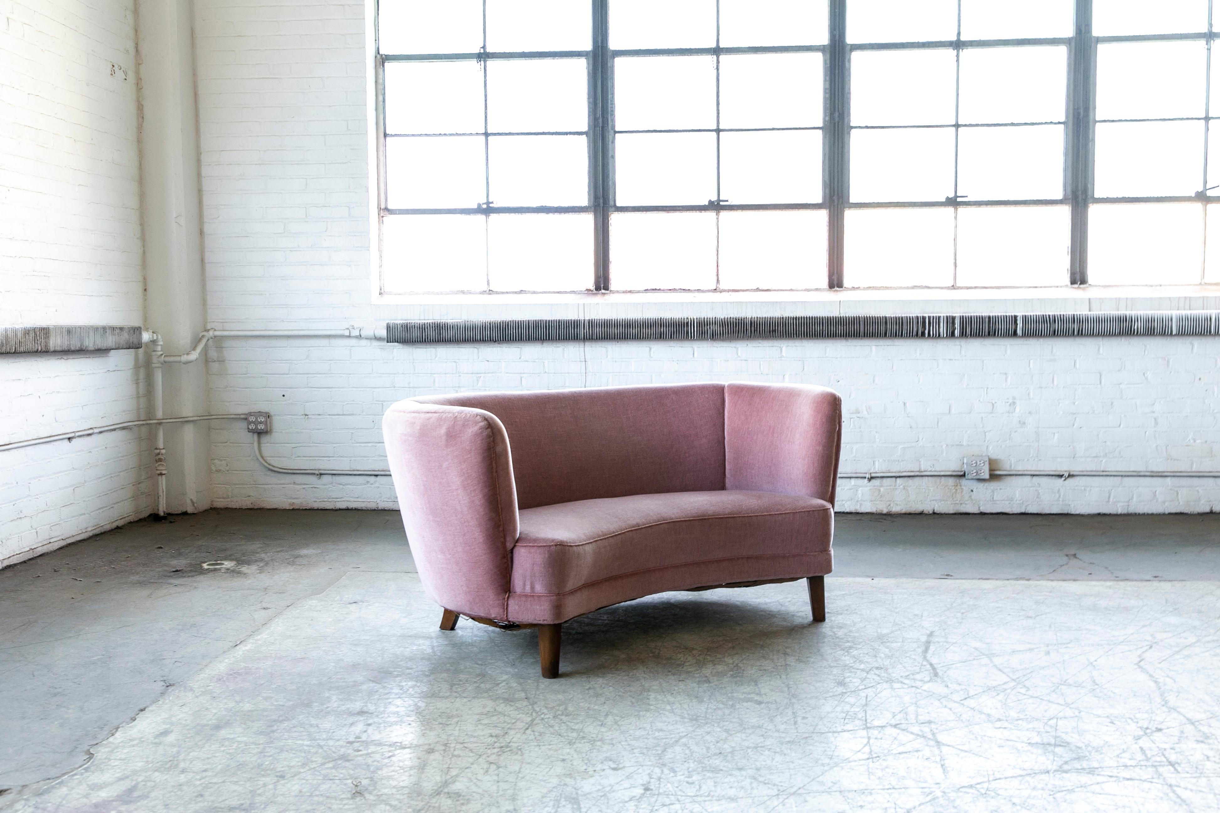 Beautiful and very elegant 1940s curved two-seat sofa or in rose pink mohair wool fabric. This sofa has slightly taller legs indicating a production date closer to 1950 when taller legs became more popular. The sofa has springs in the seat and the