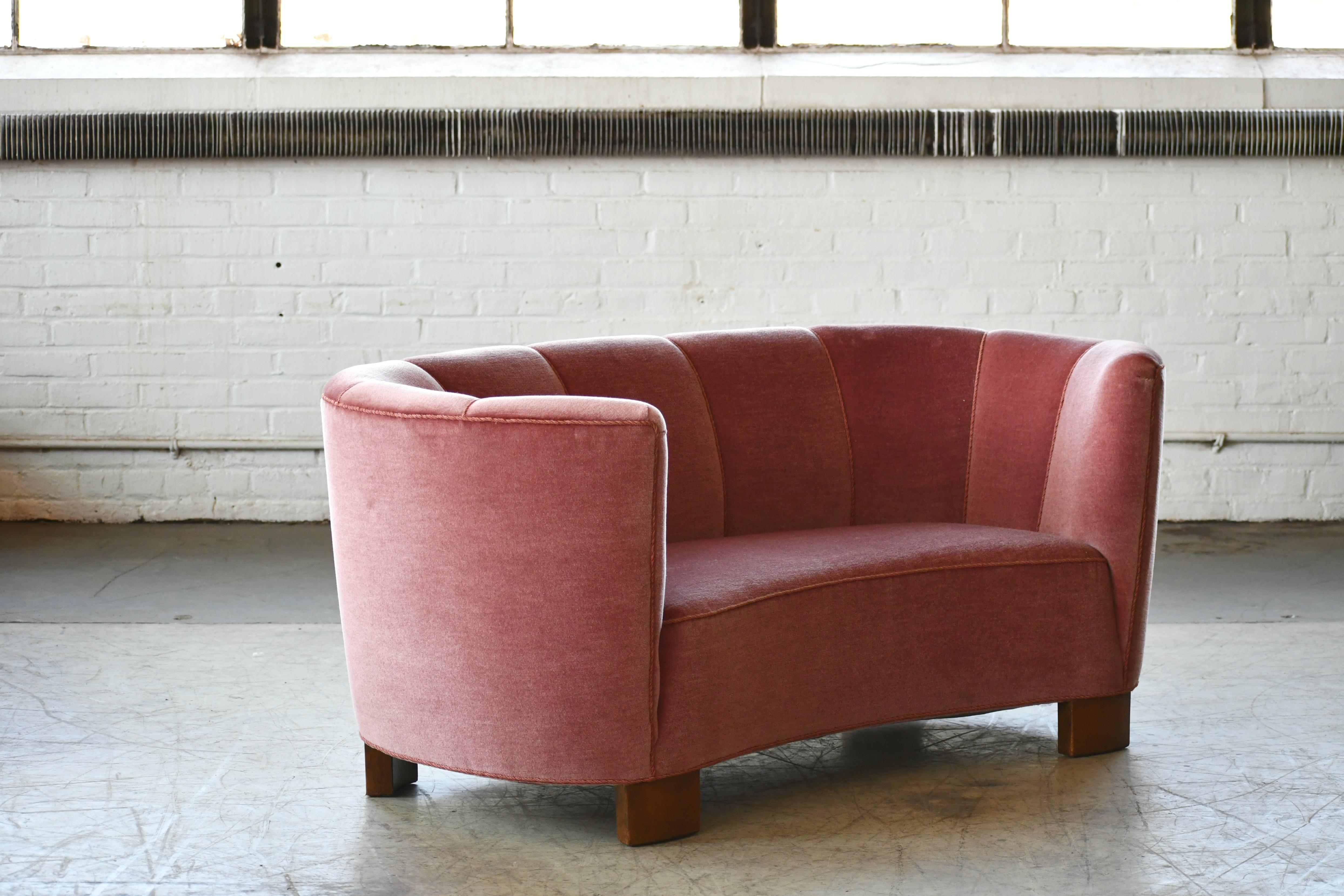 Beautiful and very elegant 1940s curved two-seat sofa or in rose pink mohair wool fabric. The sofa has springs in the seat and the backrest and the cushions are nice and firm and the sofa very sturdy. The sofa was re-upholstered in recent years and