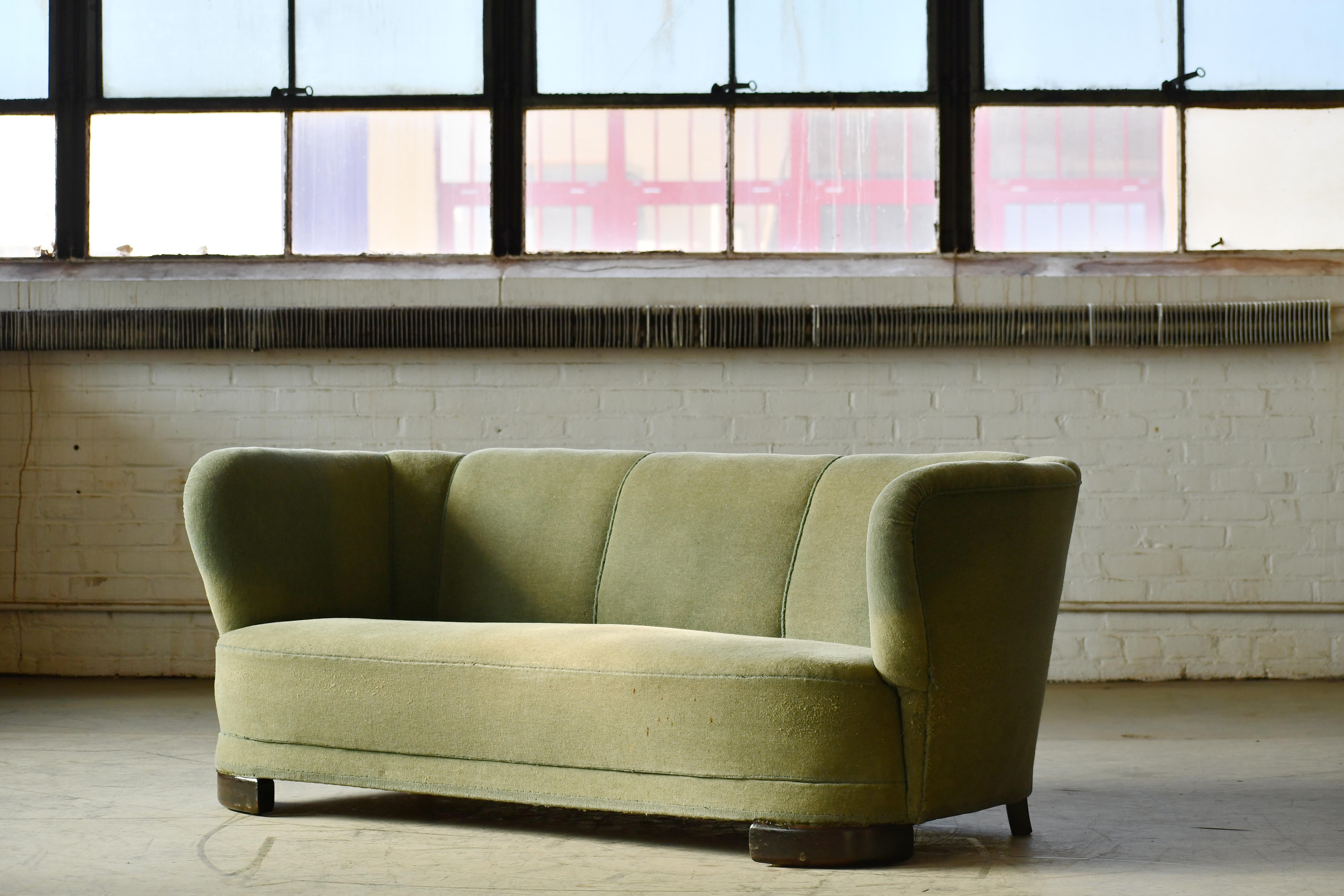 Beautiful and very elegant 1940s curved sofa in green wool fabric. The sofa has springs in the seat and the backrest and the cushions are nice and firm and the sofa very sturdy. The wool fabric is showing some signs of wear These increasingly sought