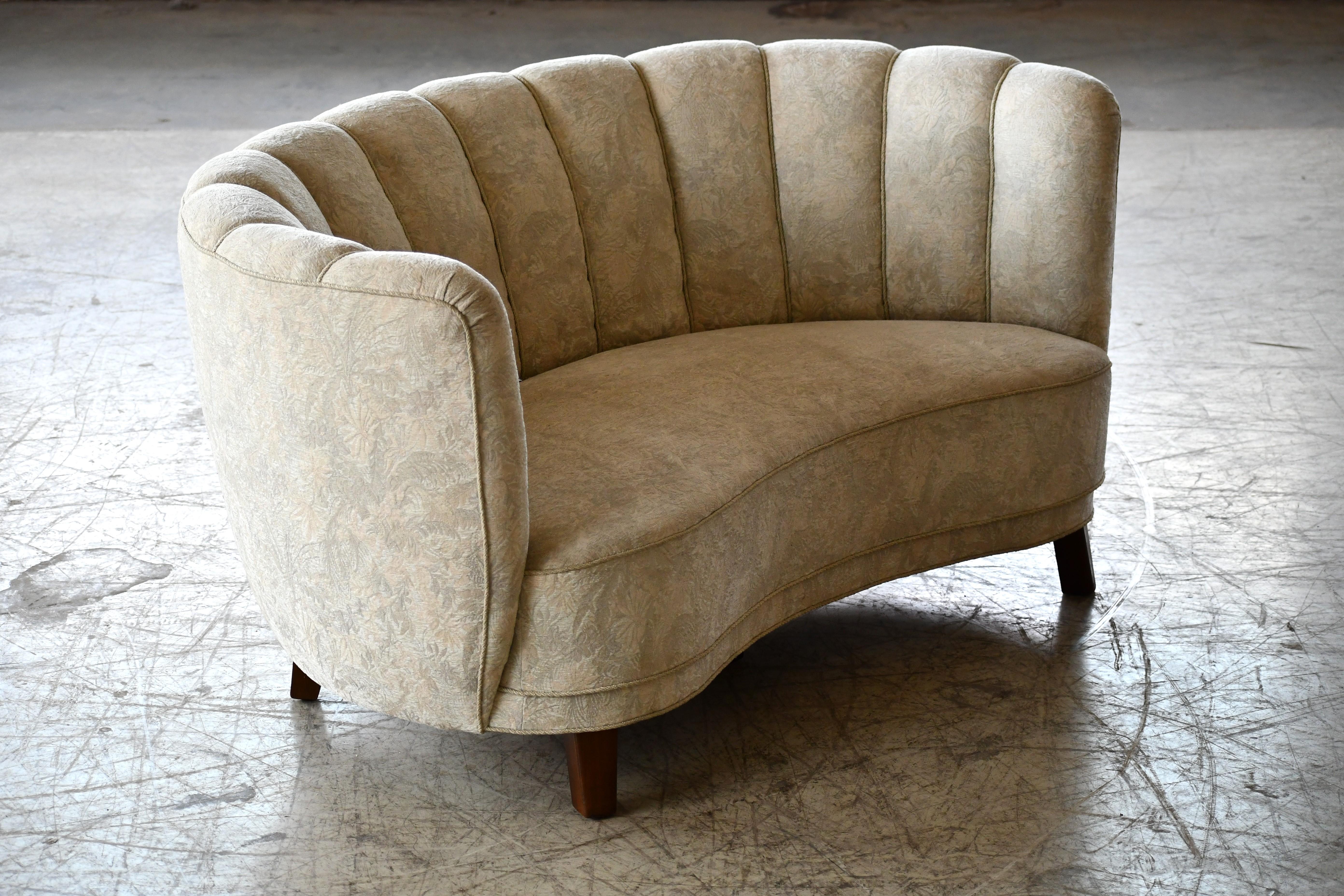 Beautiful and very elegant 1940s curved two-seat sofa or loveseat in white wool fabric. This sofa has slightly taller legs indicating a production date closer to 1950 when taller legs became more popular. The sofa has springs in the seat and the