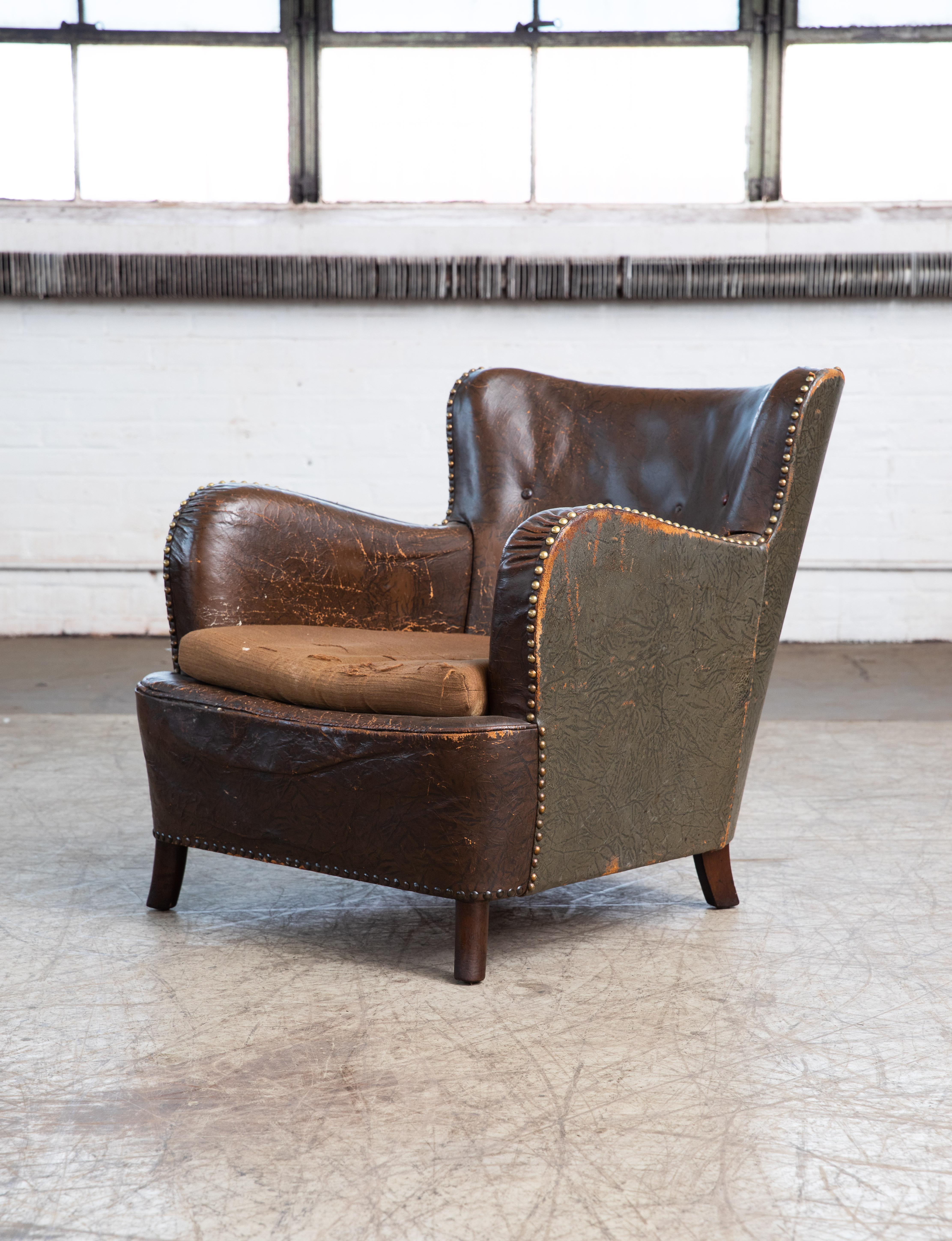 Charming Danish leather club chair from around 1940. Covered in original chocolate brown leather with a smooth back and 4 buttons. Overall good condition for its age and use with lots of noble patina and wear providing for a very authentic look.