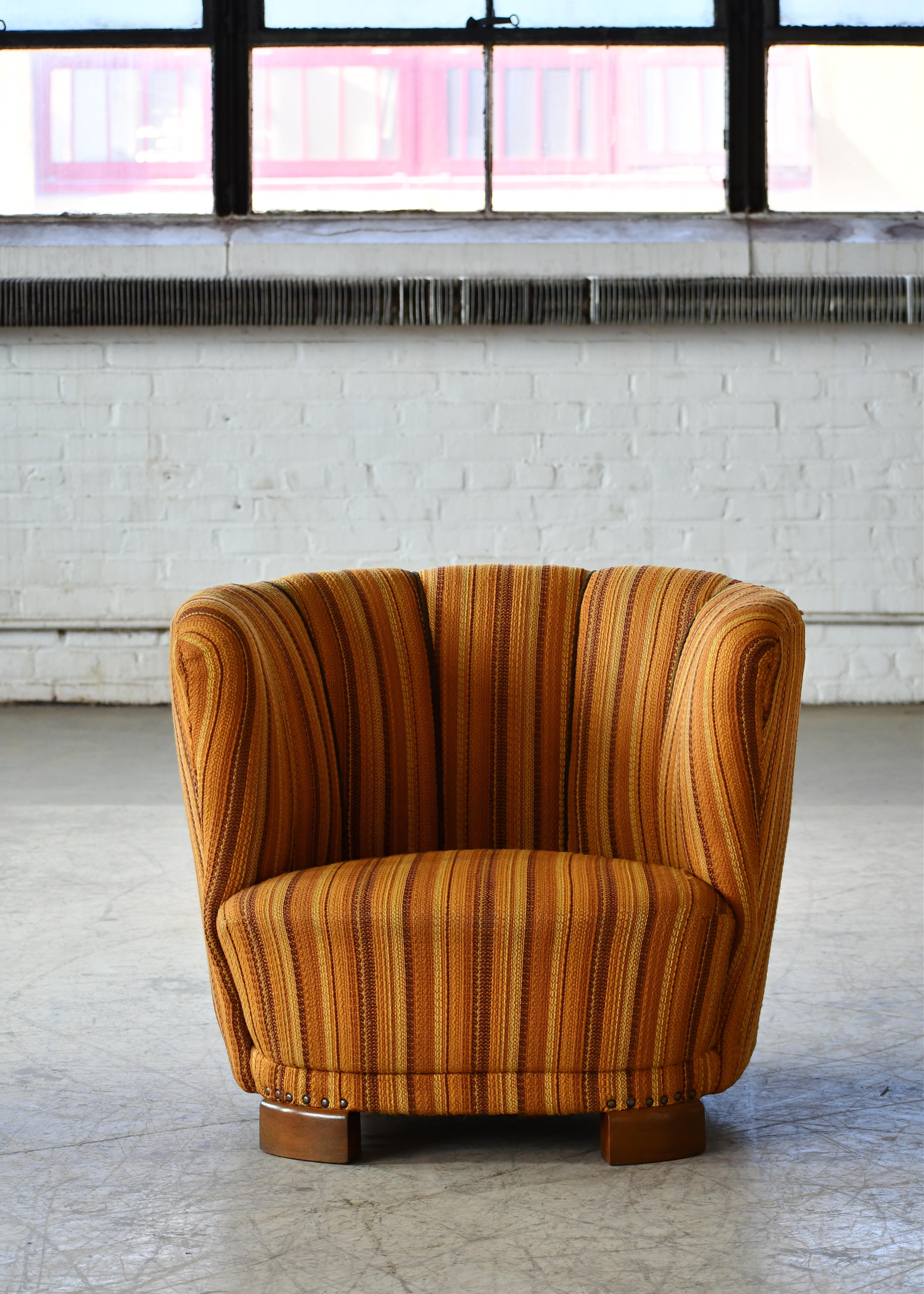 Comfortable, exuberant, and superbly made, this chair perfectly captures the essence of 1940s Danish design coming out of the late Art Deco era and into the early midcentury. The curved backrests and low slung proportions clearly hint at inspiration