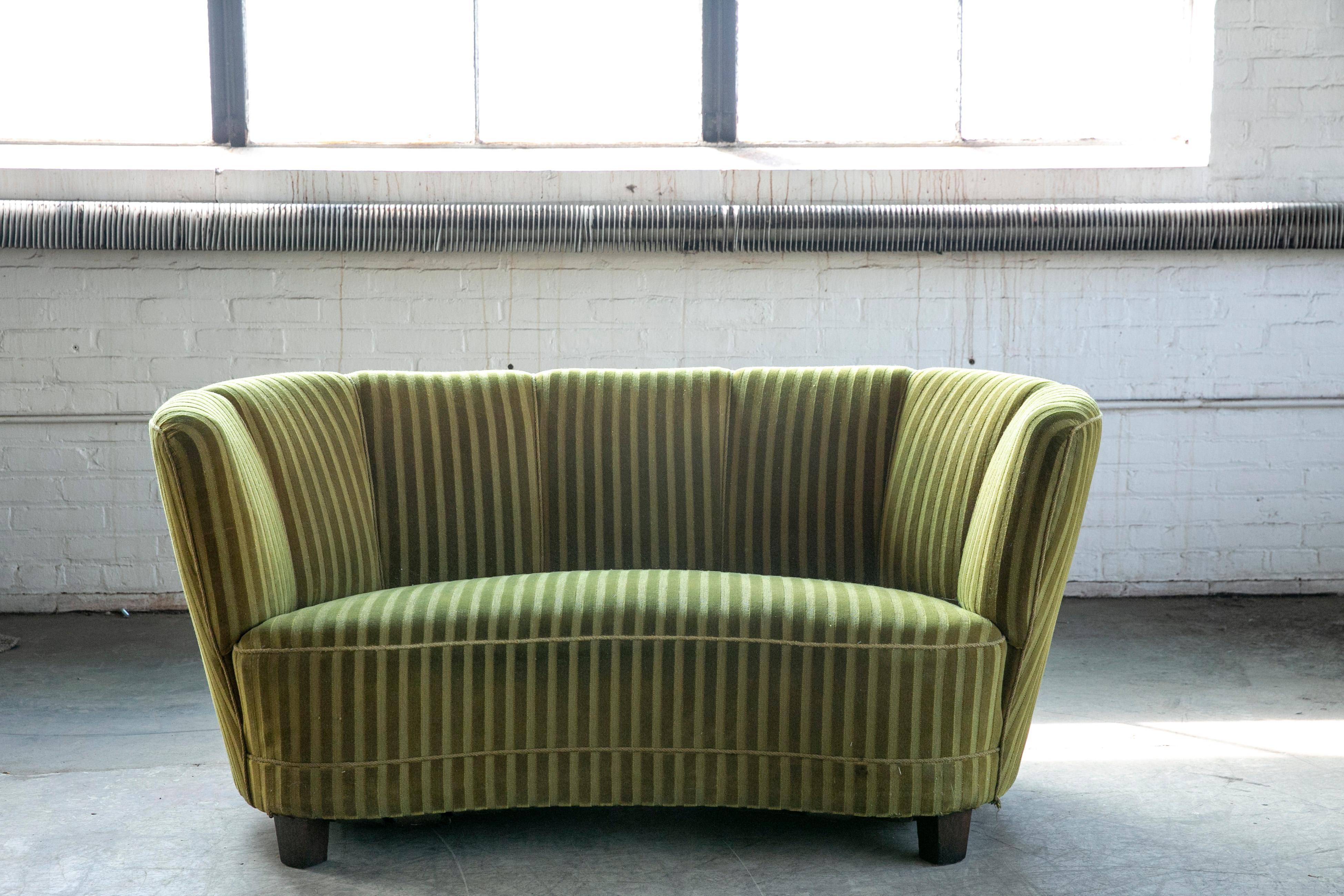Viggo Boesen style banana shaped or curved Loveseat made in Denmark, around late 1930's or early 1940's. This small sofa will make a strong statement in any room. Beautiful round voluptuous lines and solid square legs. The charming original striped