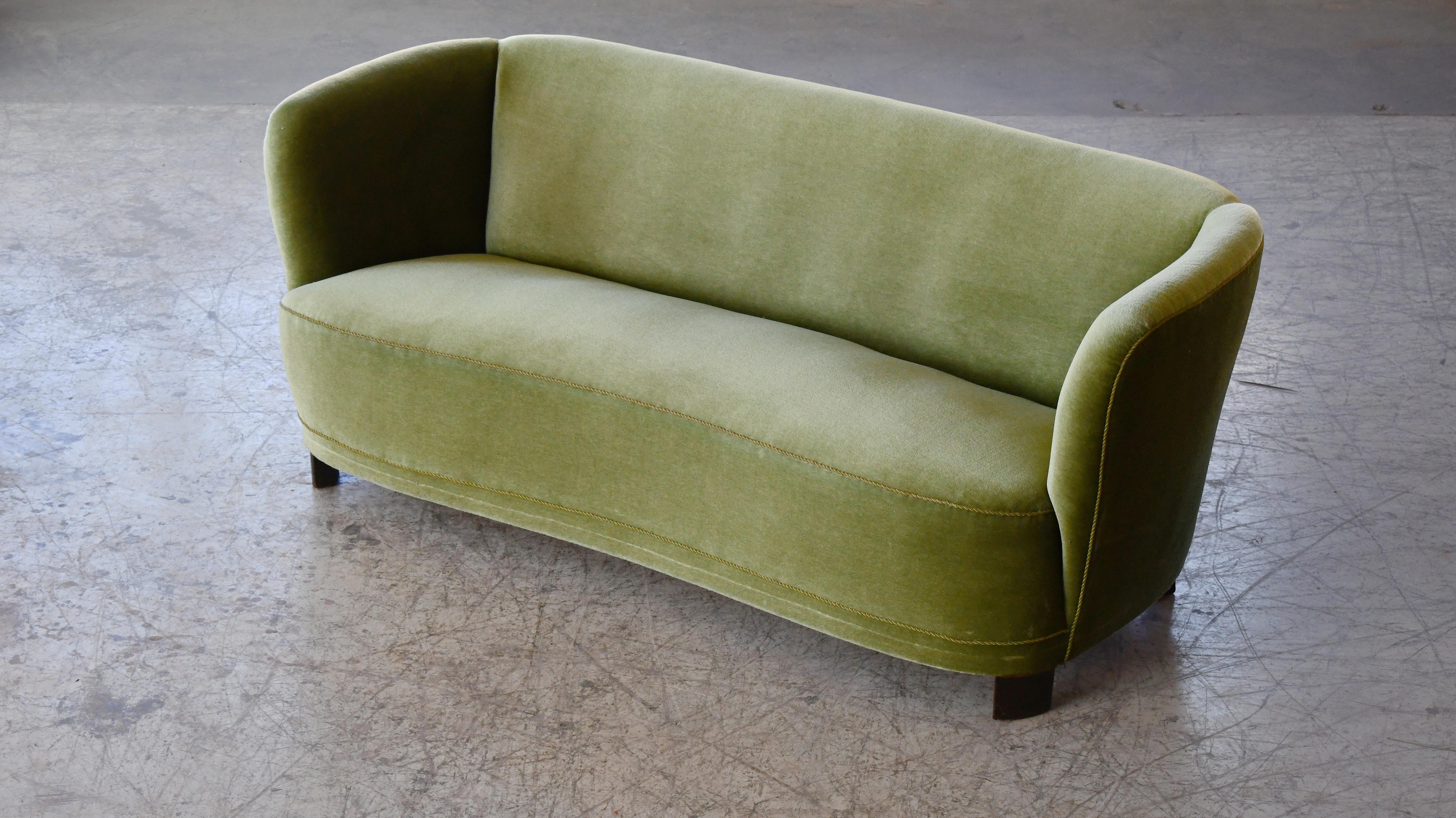 Viggo Boesen style curved loveseat made in Denmark, around late 1930's or early 1940's. This small sofa will make a strong statement in any room. Beautiful round butcher block legs with a nice clean modern look. The fabric is still clean and in
