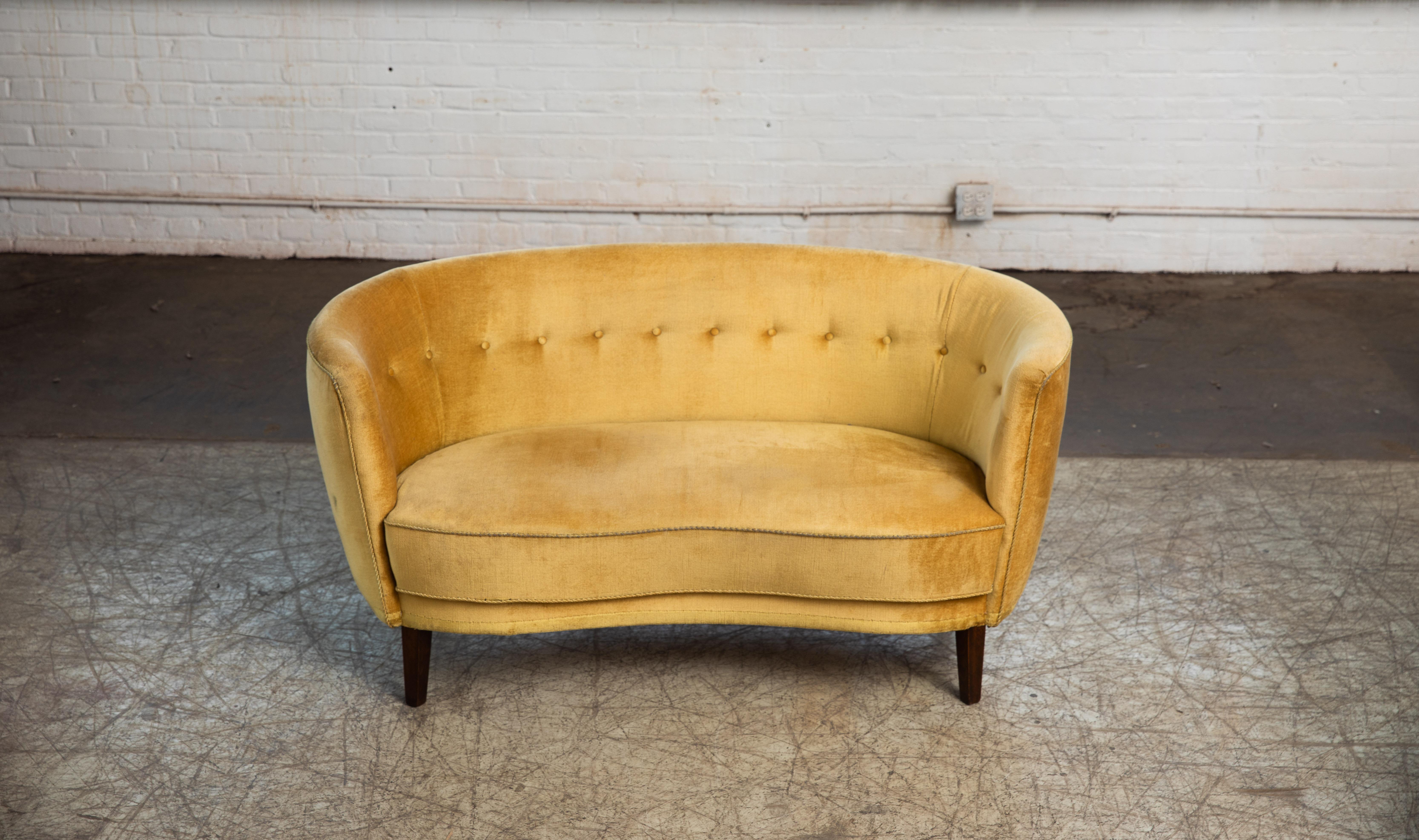 Viggo Boesen style banana shaped or curved Loveseat made in Denmark, circa 1940. This small sofa will make a nice presence t in any room. Beautiful round voluptuous lines on tall elegant legs. Original yellow mohair fabric is in usable condition.