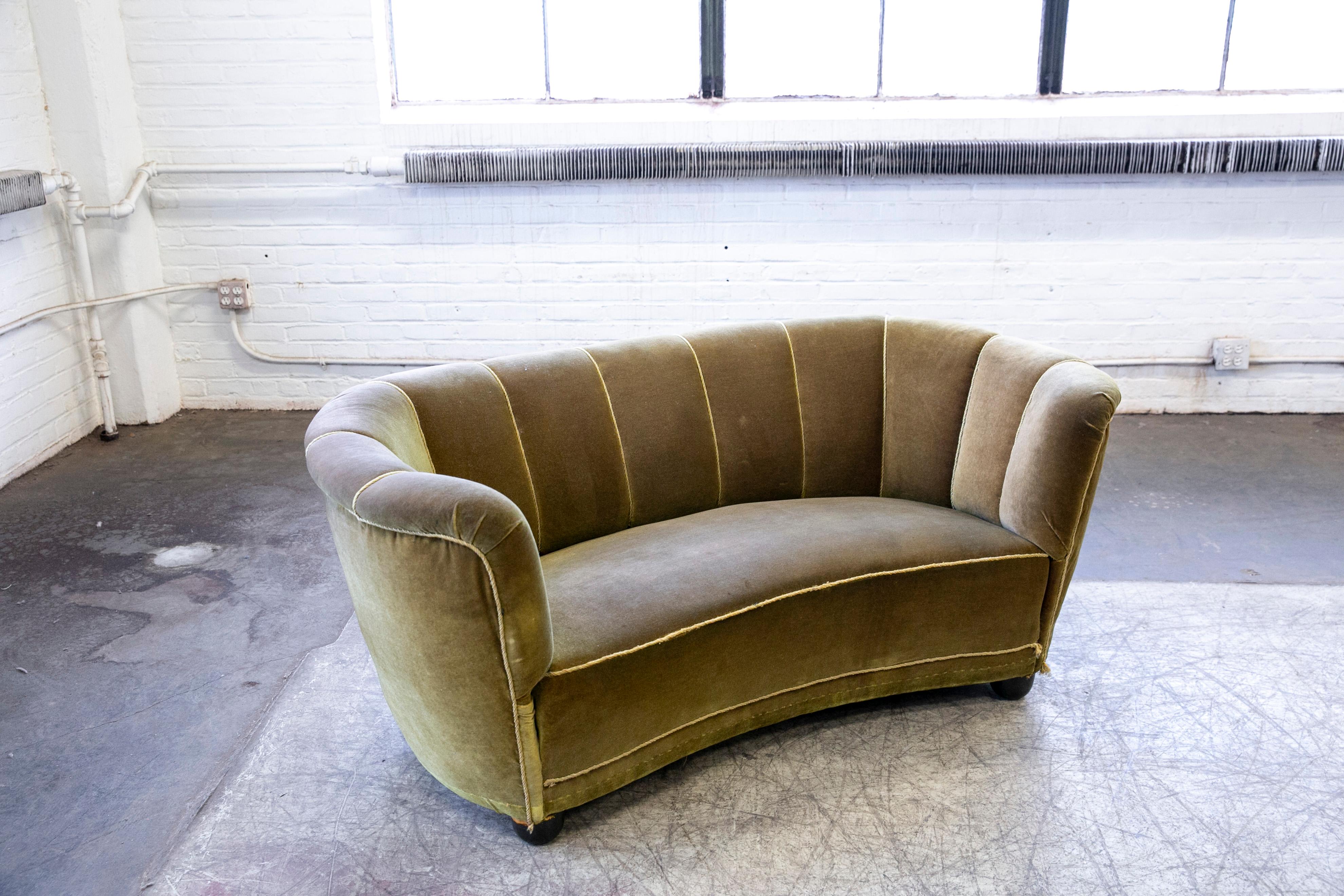Viggo Boesen style banana shaped or curved Loveseat made in Denmark, around late 1930's or early 1940's. This small sofa will make a strong statement in any room. Beautiful round voluptuous lines and solid round legs. The original fabric is