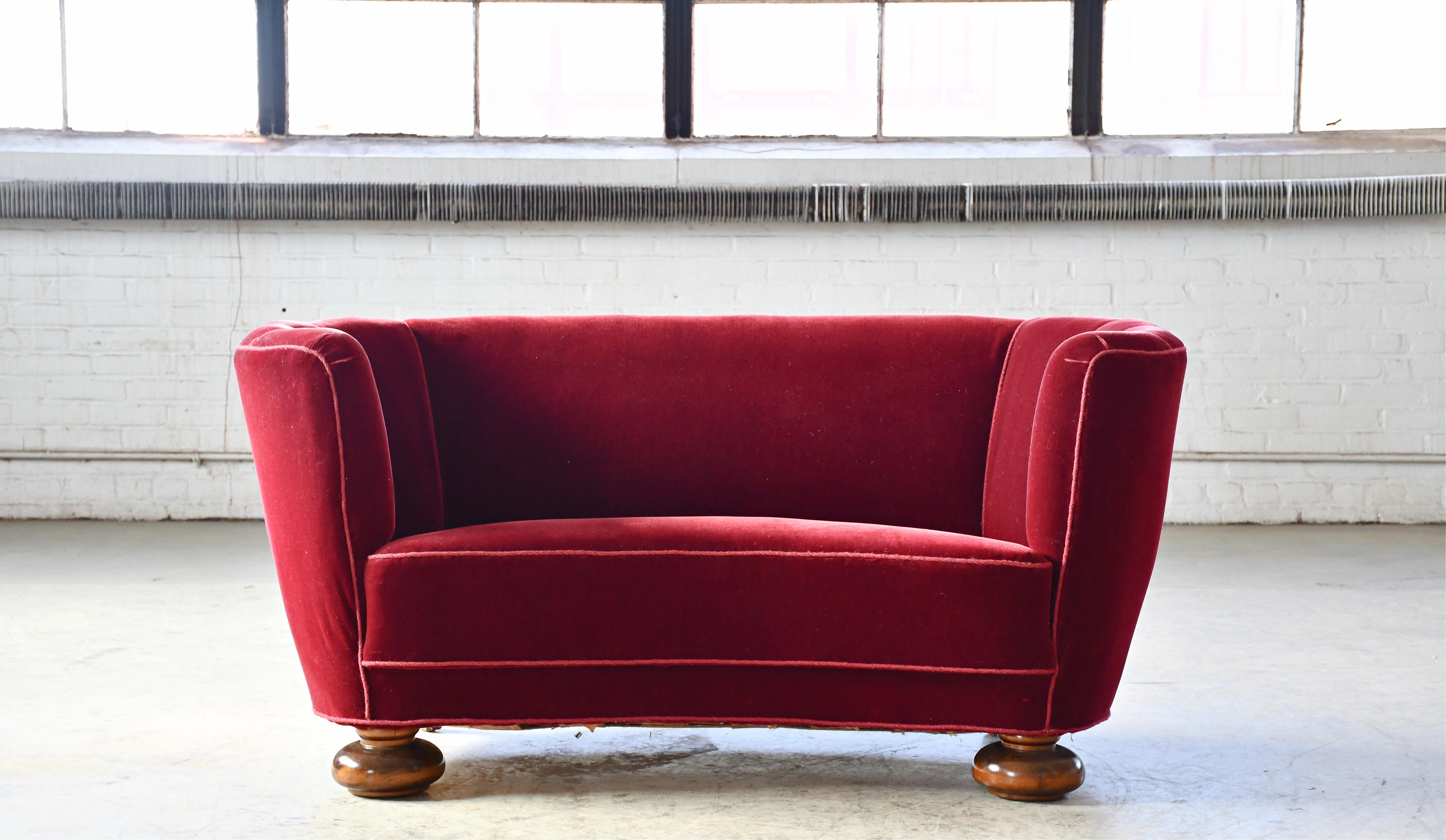 Banana shaped Viggo Boesen style curved sofa made in Denmark in the 1940s. This sofa will make a strong statement in any room. Beautiful round lines and iconic feet. Solid and sturdy. The original fabric shows minor wear but is in clean still usable