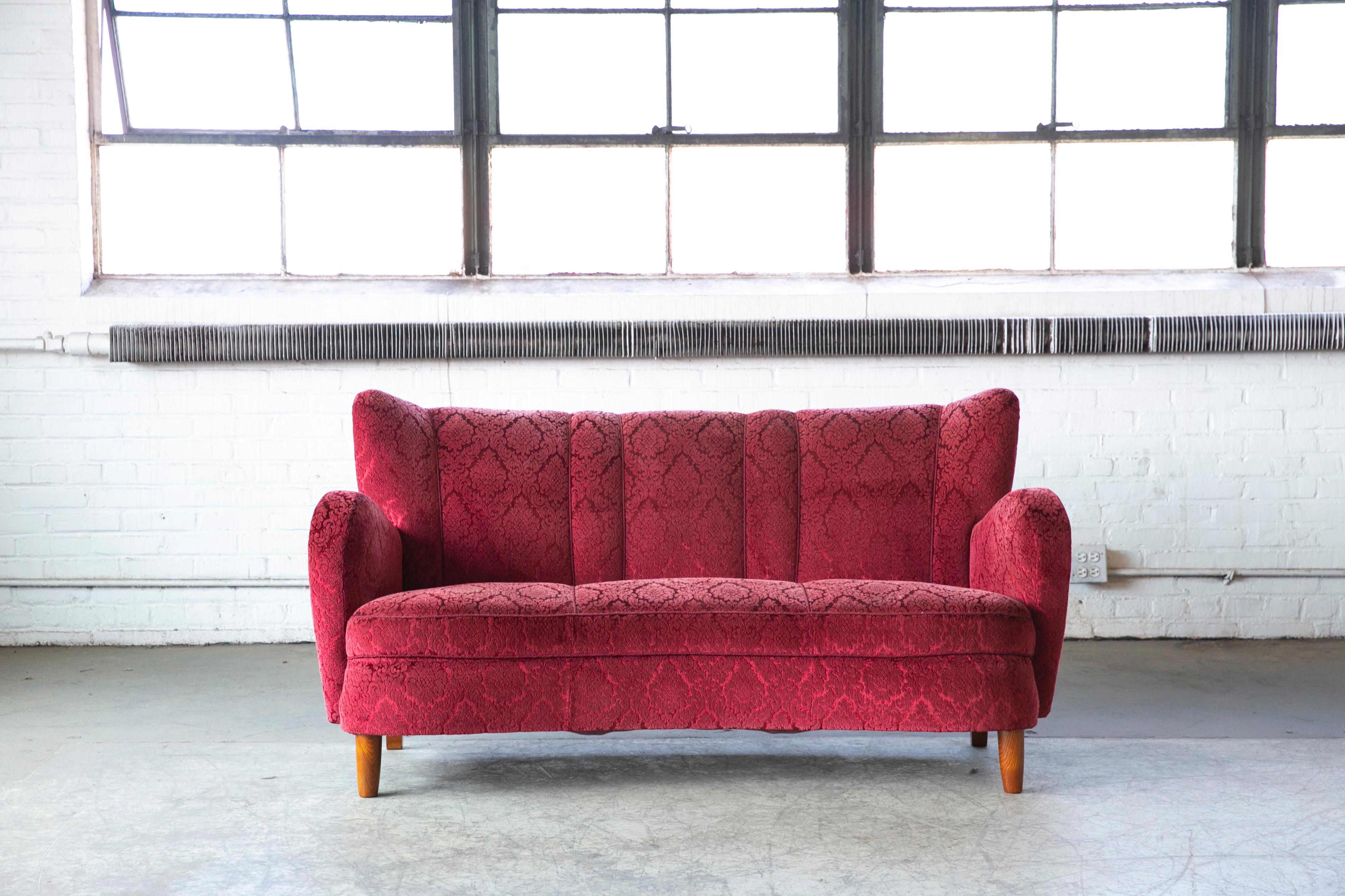 Beautiful and very elegant 1940s curved sofa/loveseat in red mohair wool fabric. The sofa has springs in the seat and the backrest and the cushions are nice and firm and the sofa very sturdy. The mohair fabric is in very clean usable condition