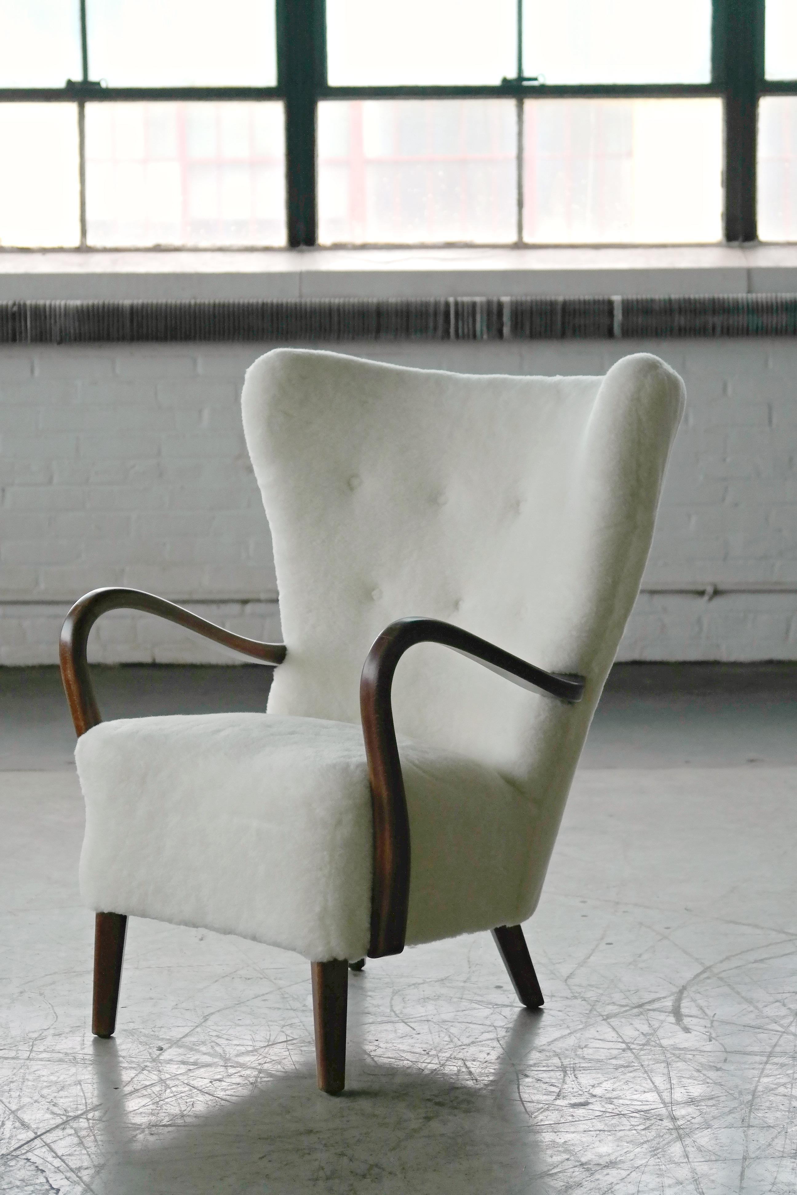 This chair is currently in transit from Denmark and will be available on or circa October 1st, 2020.

Classic elegant Danish high back armchair from the 1940s by Alfred Christensen for Slagelse Mobelvaerk with open armrests in beautifully curved