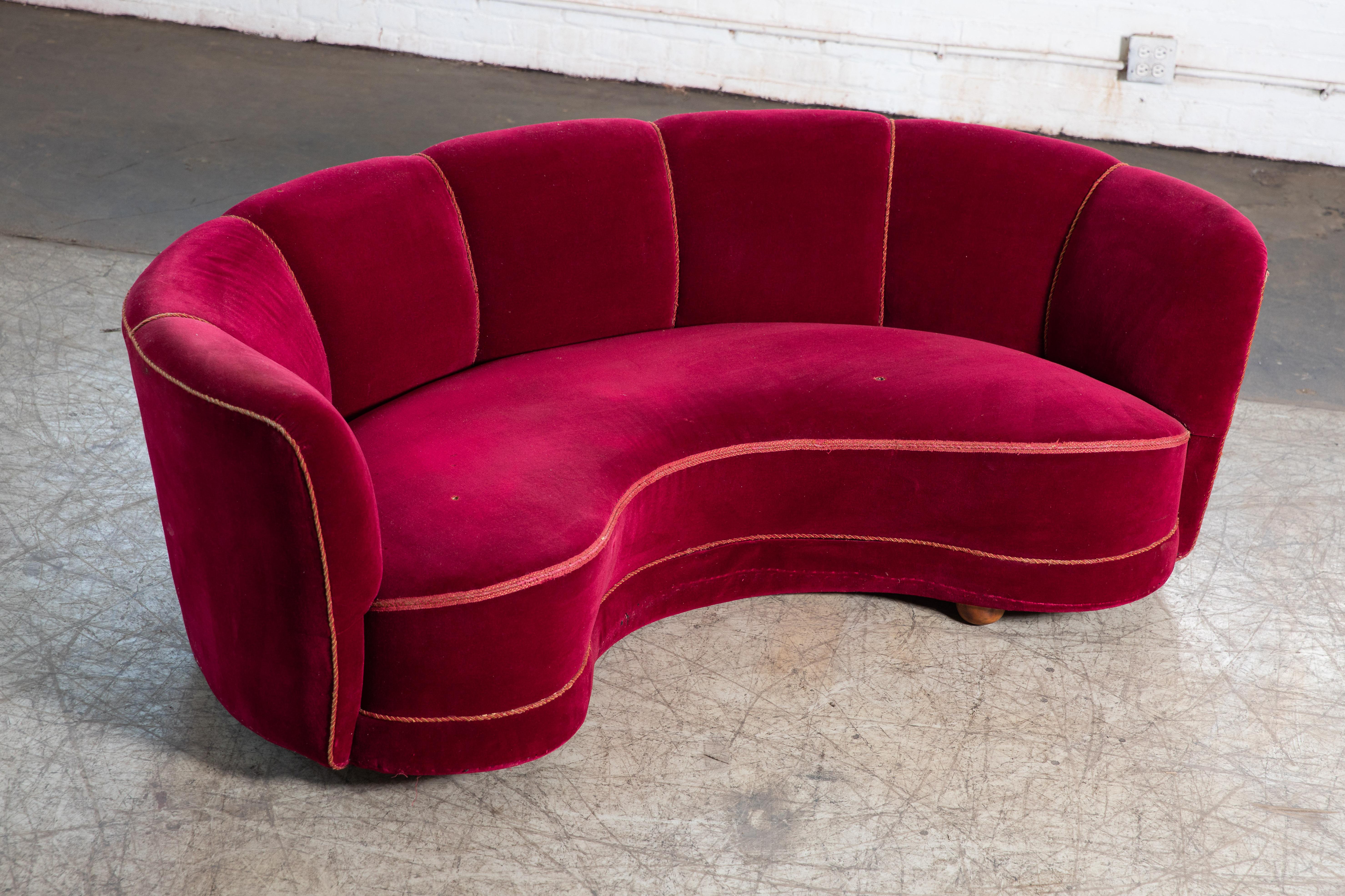 Viggo Boesen style banana shaped or curved sofa made in Denmark, circa 1940. This sofa will make strong statement in any room. Beautiful round voluptuous lines and with large block legs providing a for an elegant and inviting look. Compared to other