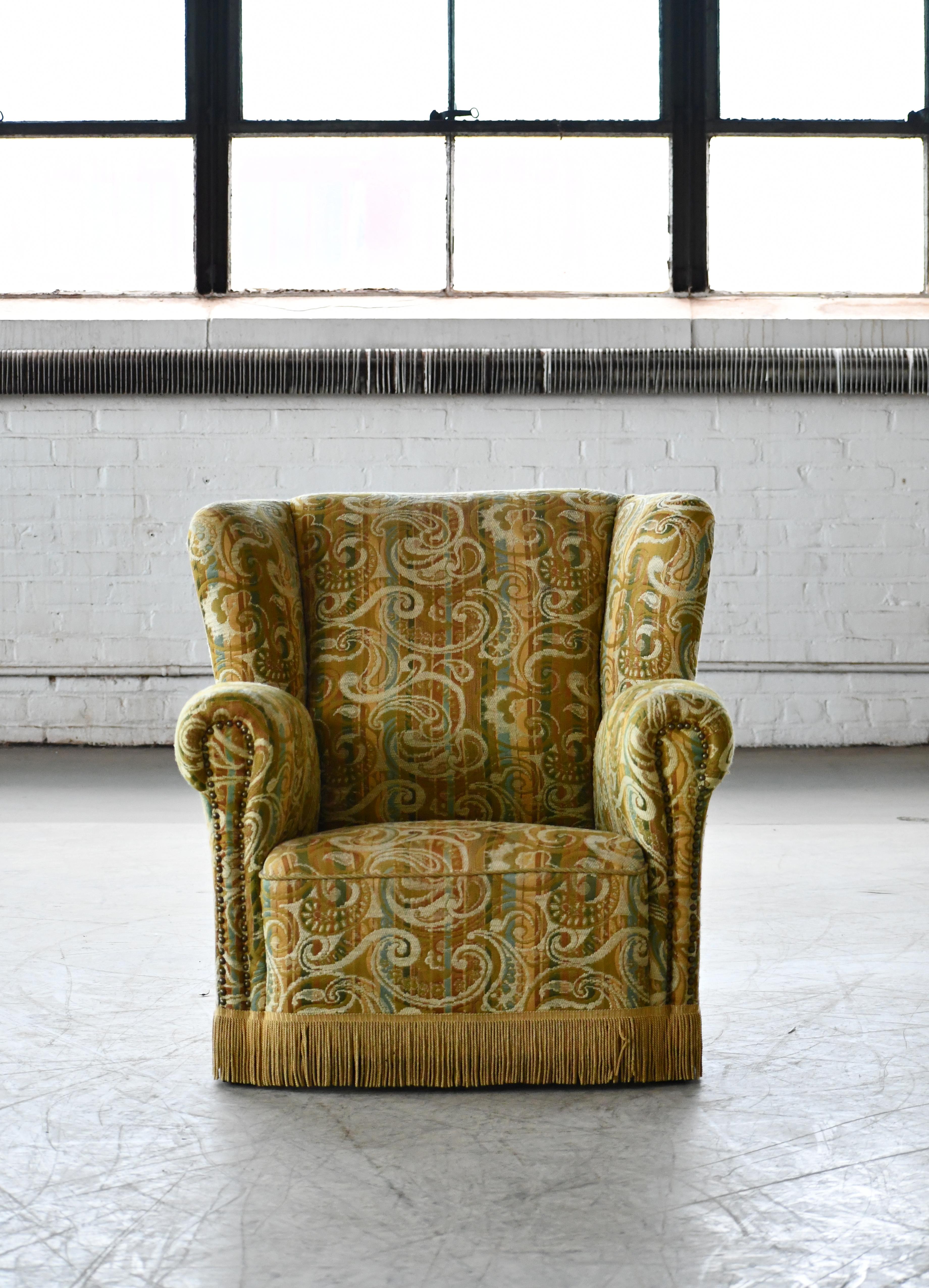 Großer dänischer Sessel aus den 1940er Jahren. Hergestellt mit Federspulen und in der Sitzfläche und Rückenlehne. Später neu gepolstert und in sauberem, gebrauchsfähigem Zustand mit nur minimalen Gebrauchsspuren. Der Stuhl ist nicht gekennzeichnet,