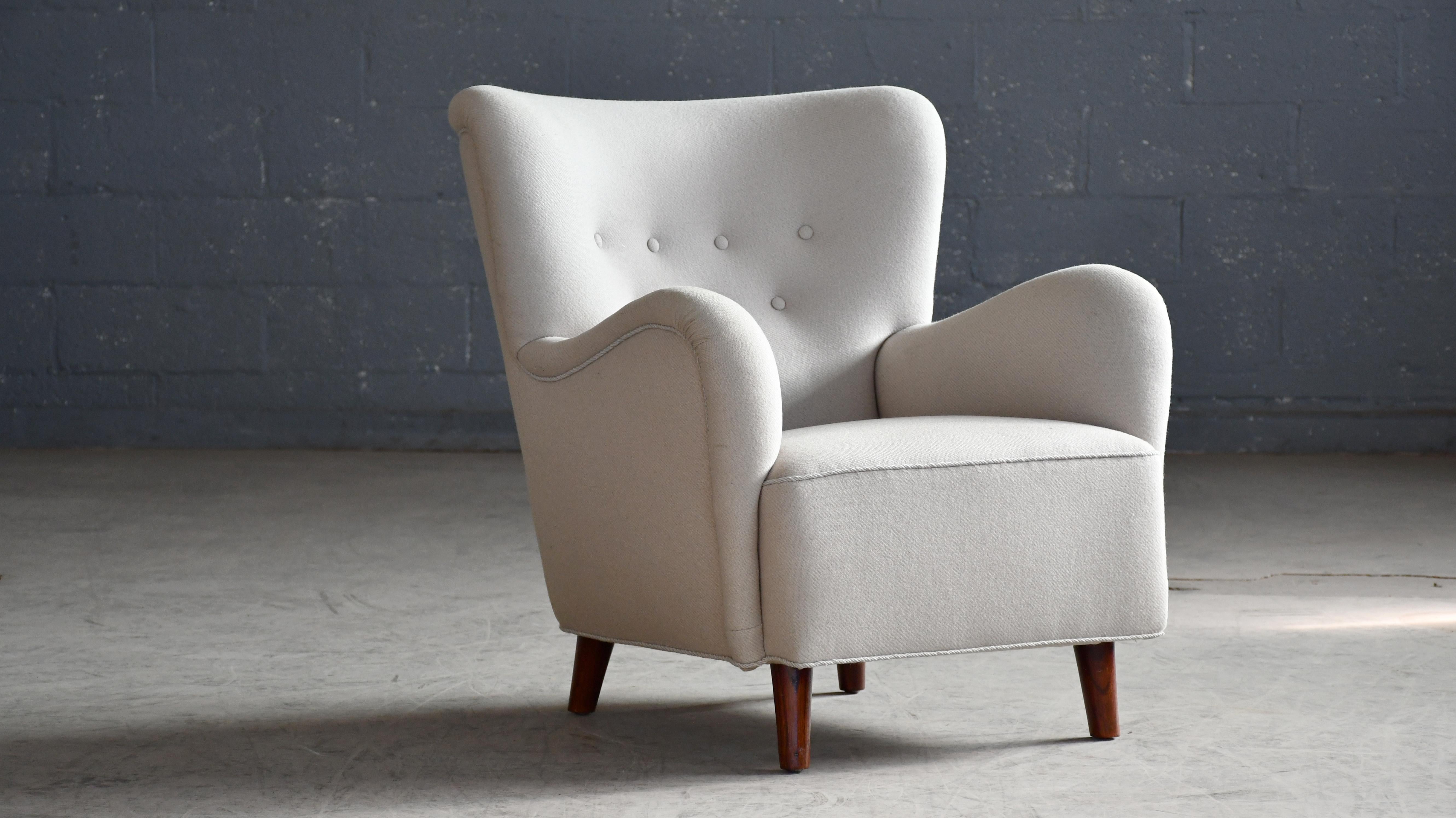 Encantador sillón de media altura de los años 40 al estilo de Flemming Lassen, con una forma orgánica muy escultural y proporciones armoniosas. Buena presencia y muy cómoda. Levantada sobre patas de haya teñida y marco de haya. Los muelles del