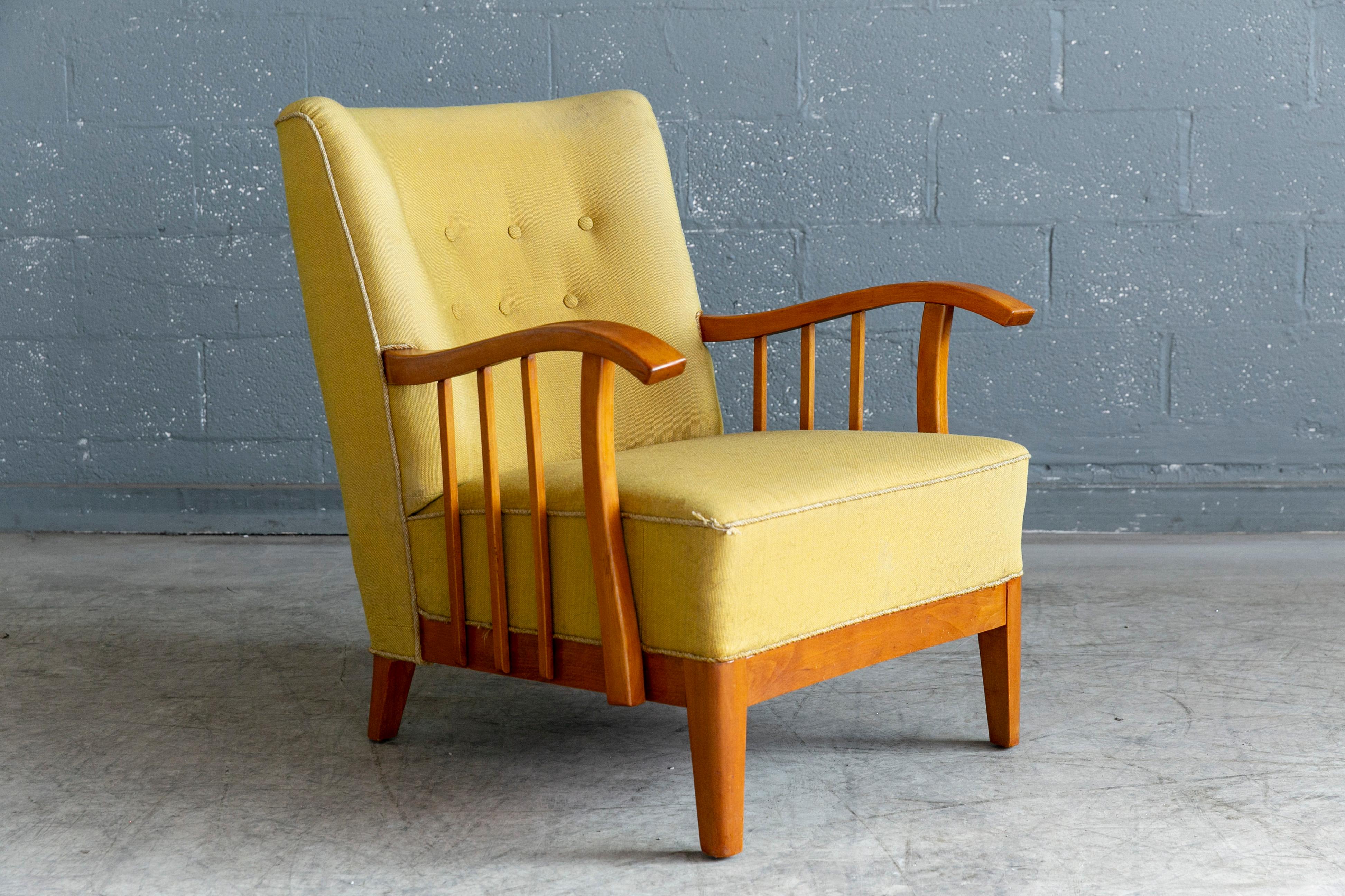Beautiful and very unique Danish 1940s lounge chair with nicely carved armrest in blond lacquered elmwood. Light elegant design in the style of Alfred Christensen and Fritz Hansen although we are not aware of the maker or Designer of the chair. The