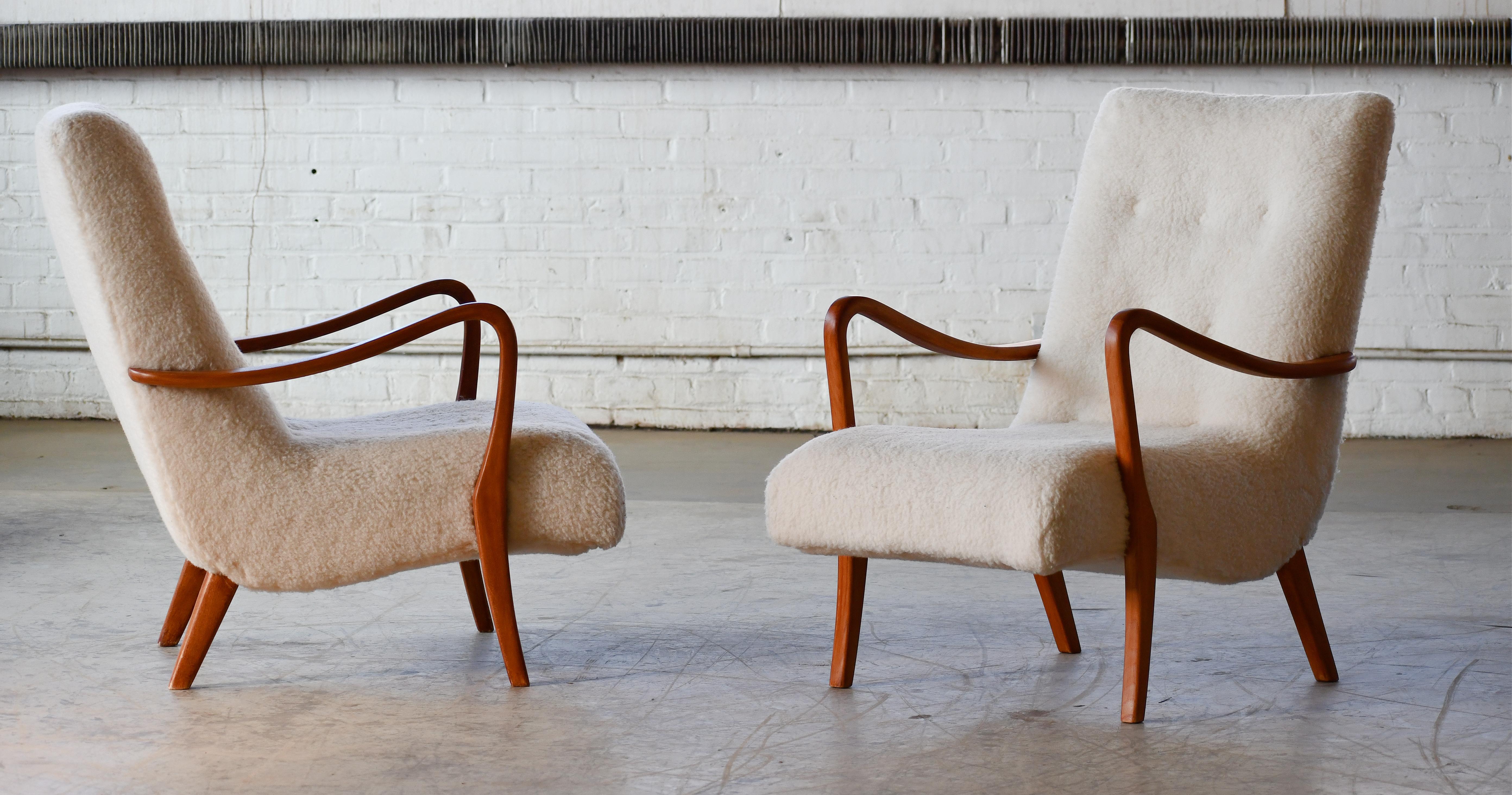 Super elegant Danish pair of lounge chair  from ca. 1950 attributed to Alfred Christensen . Open armrests in beautifully curved stained beech. Nice slim elegant silhouette. Solid and sturdy construction with the fabric in still usable condition,