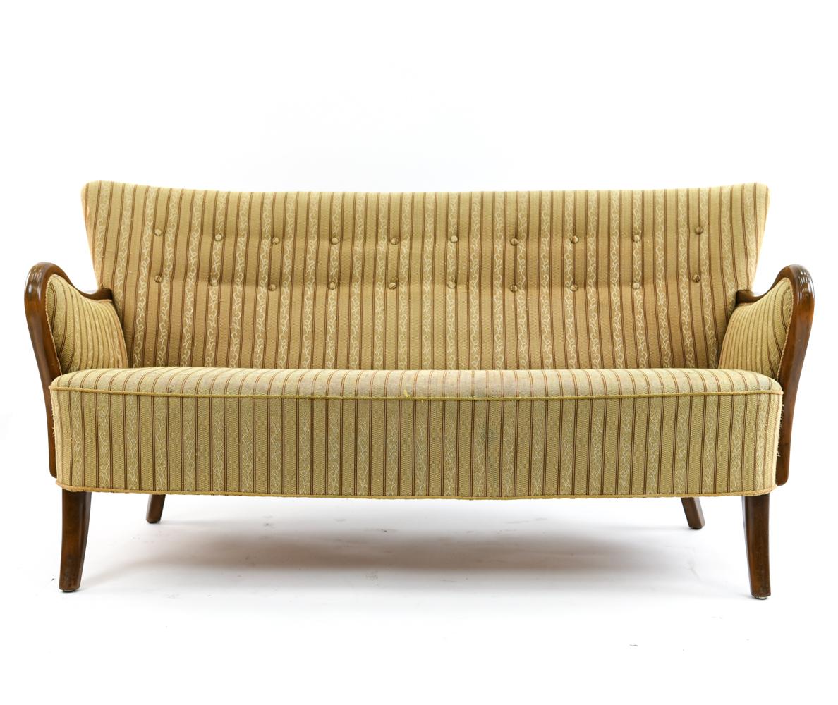 A fantastic 1940s sofa designed by Alfred Christiansen for Slagelse Mobelvaerk in his characteristic style. This sofa features closed arms and a button-tufted back. Although the striped upholstery may seem dated, this provides a great clean slate