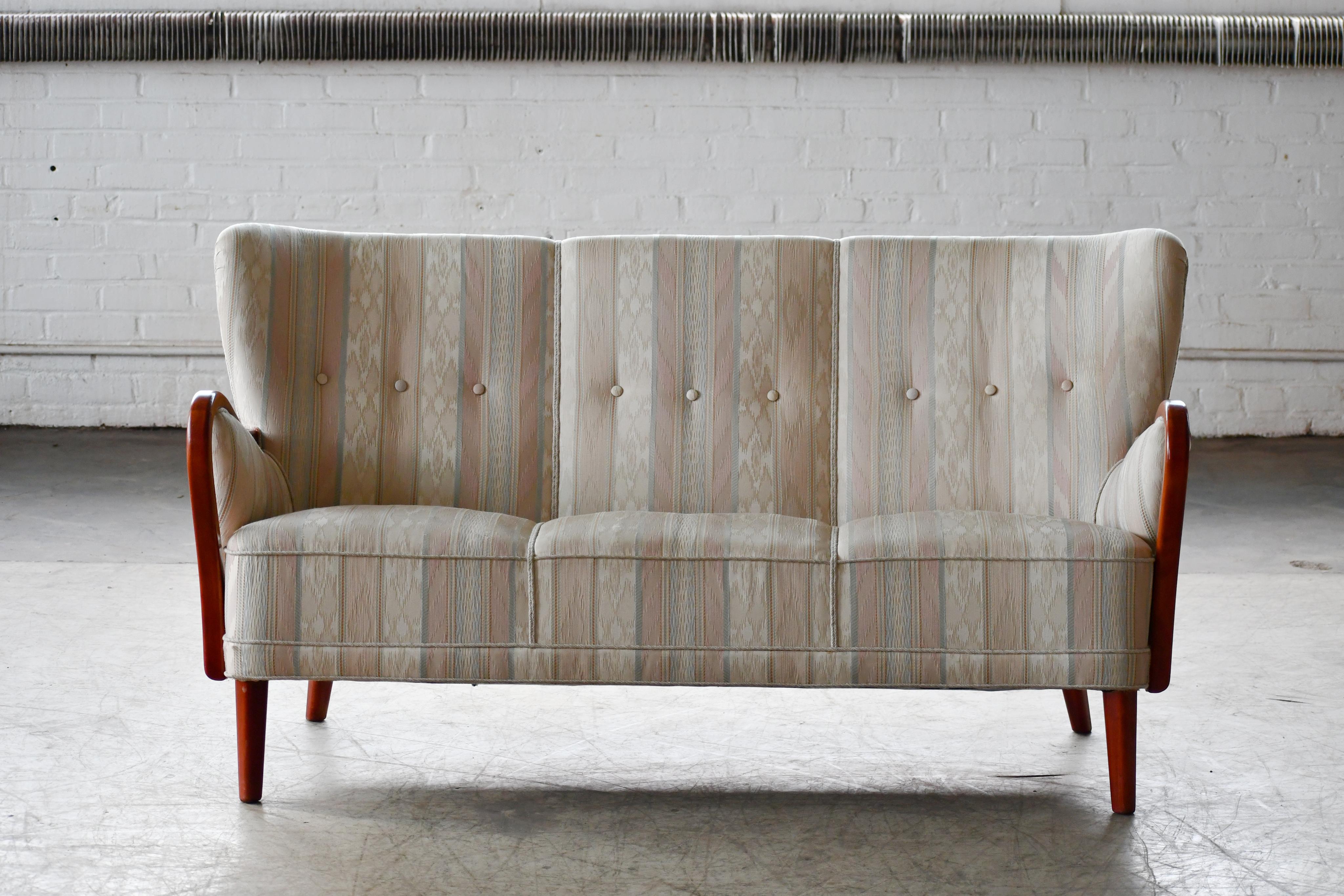 Fantastic 1940s Alfred Christensen designed sofa in his characteristic style of open armrests carved from solid elm wood and made by Slagelse Mobelvaerk in the 1940s. Beautiful refined lines with curving arms, coil springs in the seat and tufted
