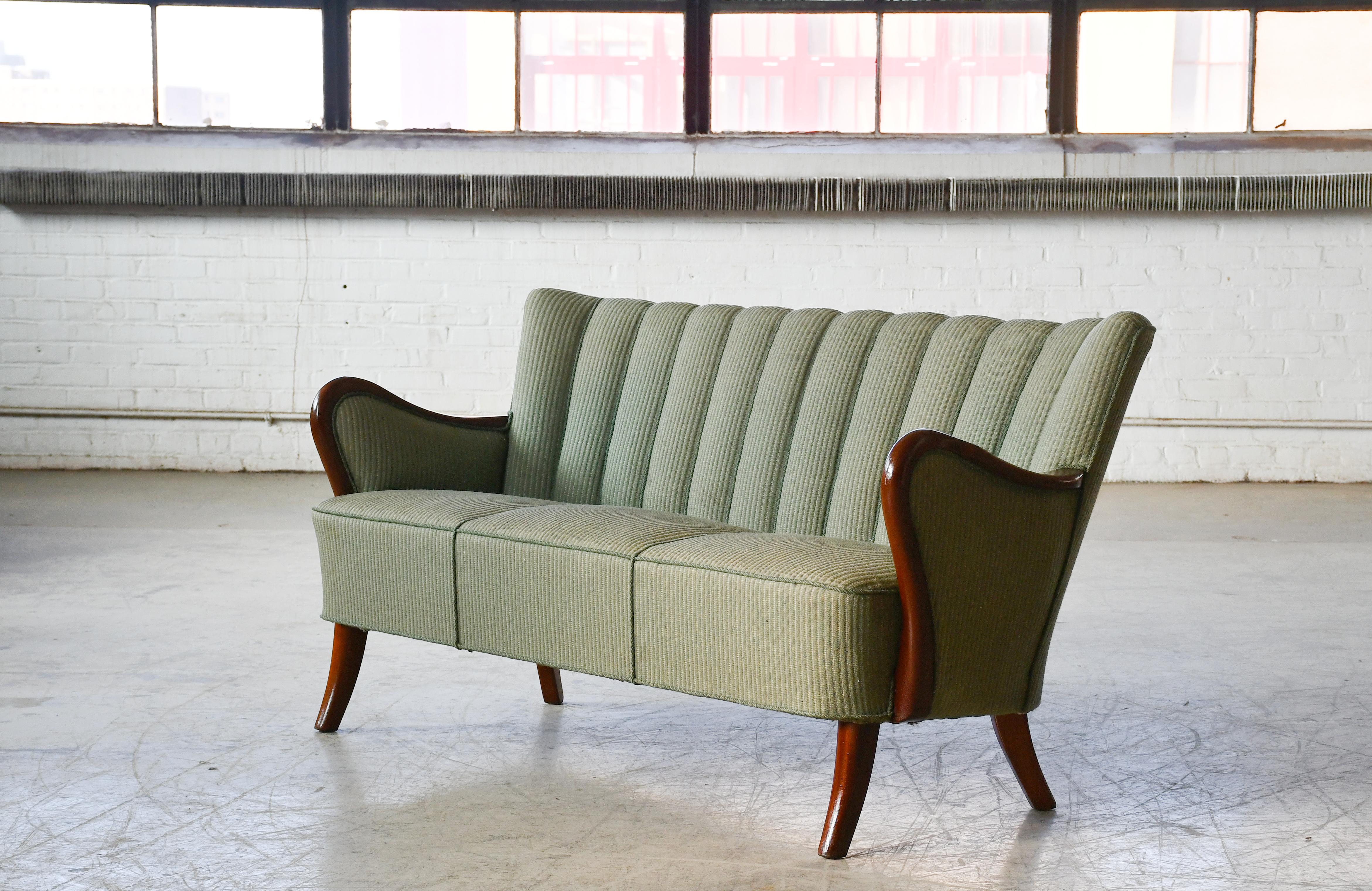 Fantastico divano degli anni '40 progettato da Alfred Christensen nel suo caratteristico stile con braccioli in legno intagliati in legno massiccio di olmo e realizzato da Slagelse Mobelvaerk negli anni '40. Bellissime linee raffinate con braccioli