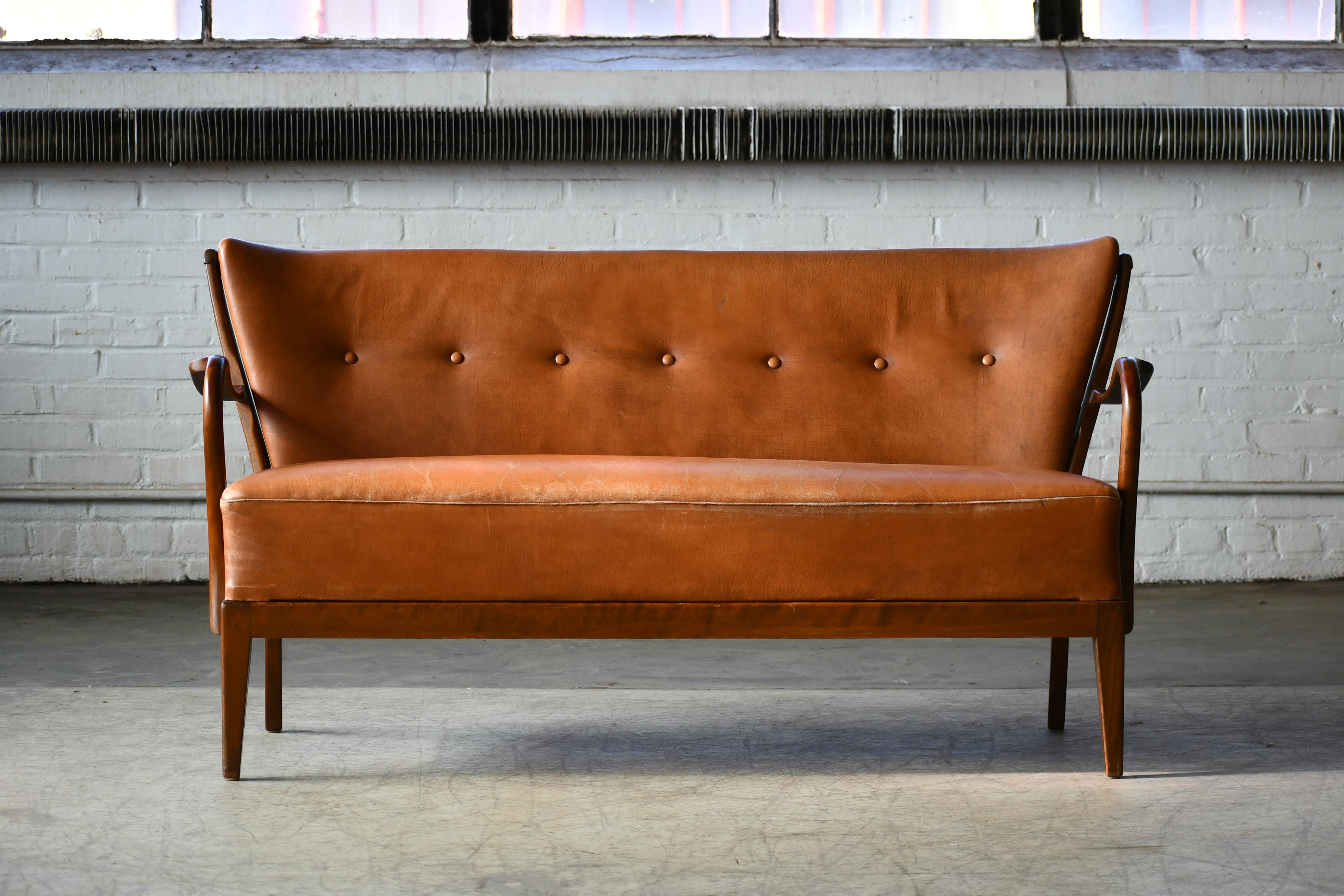 Fantastic 1940s Alfred Christensen designed sofa in his characteristic style of open armrests and spindle back carved from solid beech wood and made by Slagelse Mobelvaerk as model 93 in the 1940s. The sofa was seen in Slagelse's cagalog no. 4401