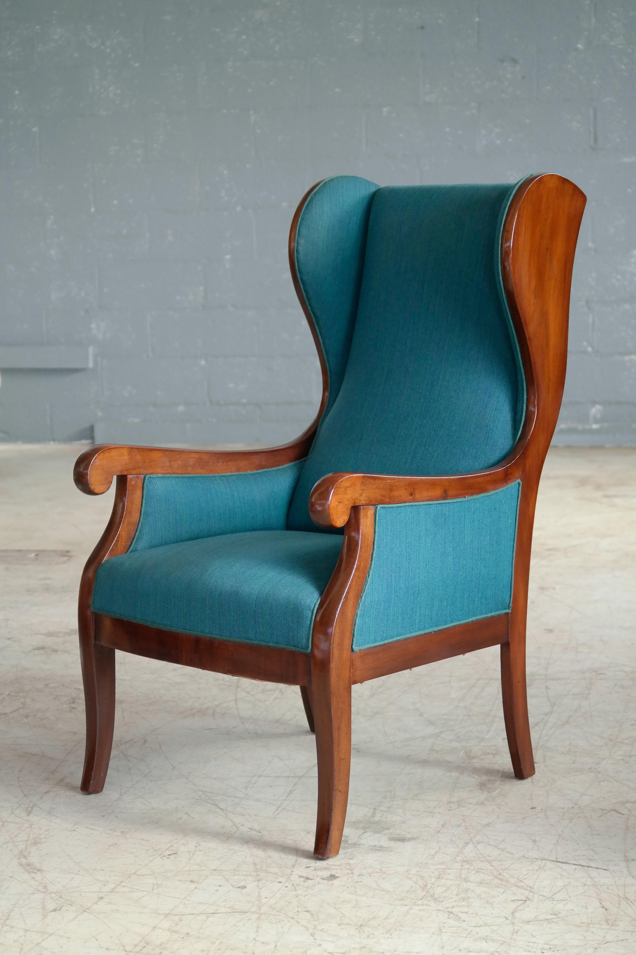 Beautiful classic 1930s-1940s solid mahogany and wool wingback chair produced by Master Cabinetmaker Frits Henningsen, Denmark. Very elegant design that fits superbly into any modern design making a strong yet refined statement. Excellent conditions
