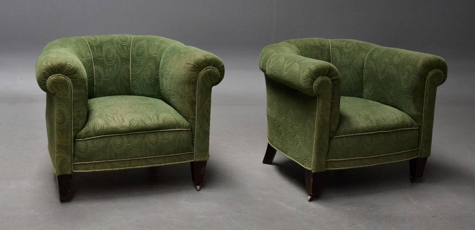 Danish 1950s Chesterfield style pair of club chairs very similar to some of famed Otto Schulz' designs from the 1940s. Sturdy and solid raised on legs of stained beech with wheels on the front legs. Fabric is clean but shows signs of moderate wear