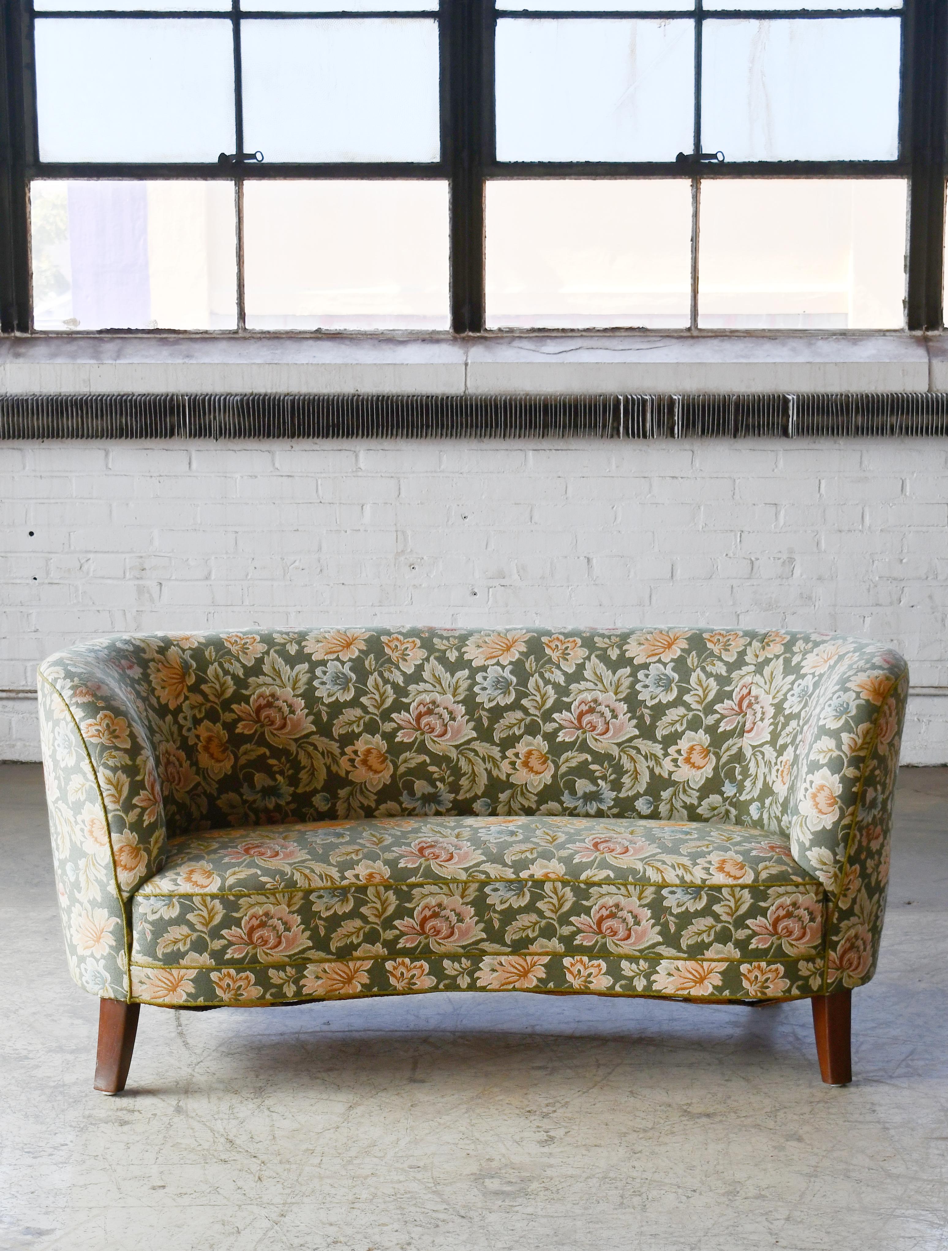 Banana shaped or curved loveseat made in Denmark, around early 1950s. This small sofa will make a strong statement in any room. Beautiful round voluptuous lines and tall legs. These sofas were typically made up through the 1930s to early 1950s and