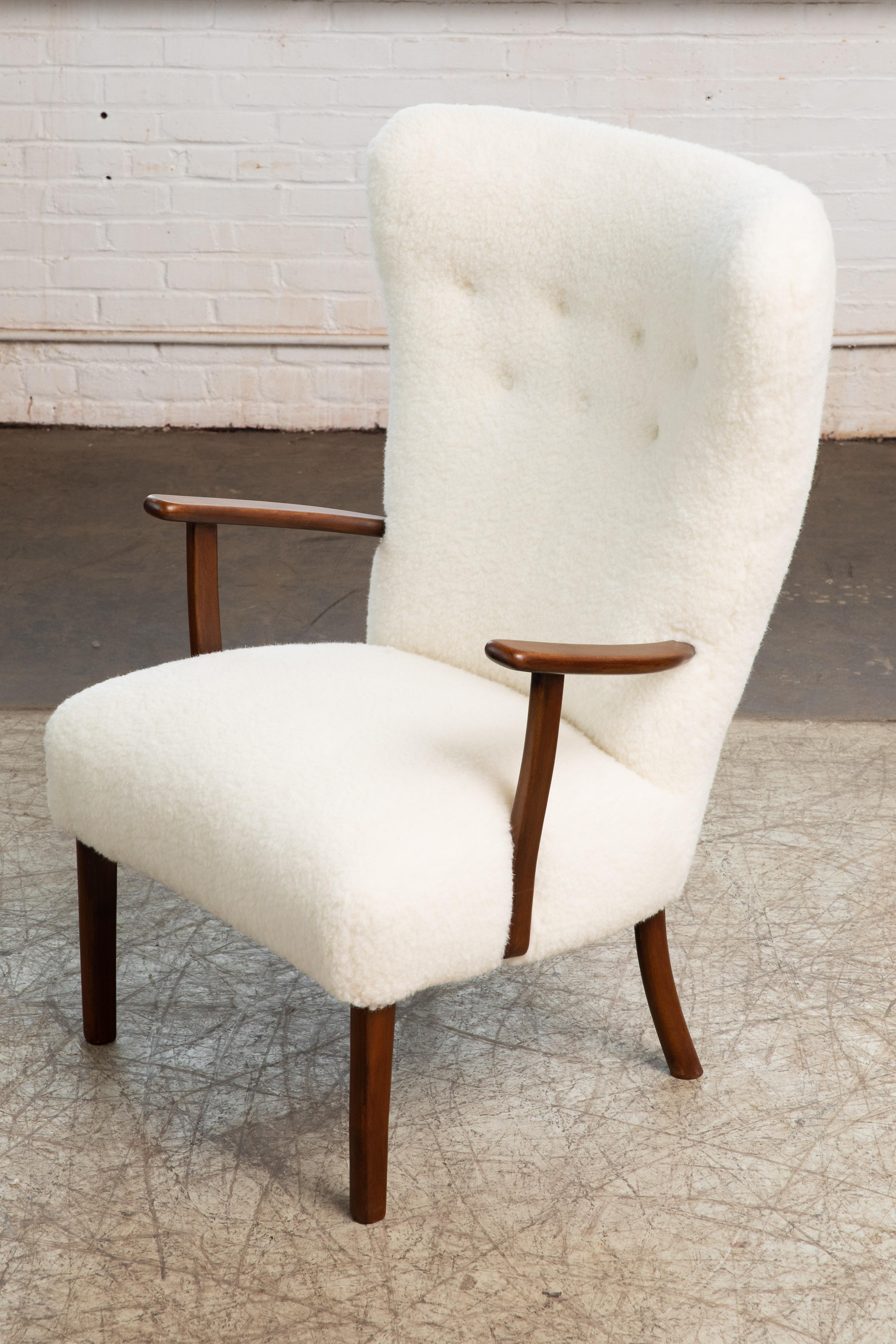Beautiful Danish 1950s highback lounge chair with open armrests in stained beechwood model 1644 by Frits Hansen Marked by the Maker. Light elegant silhouette while still sturdy and strong. Fully refurbished and newly upholstered in a smooth