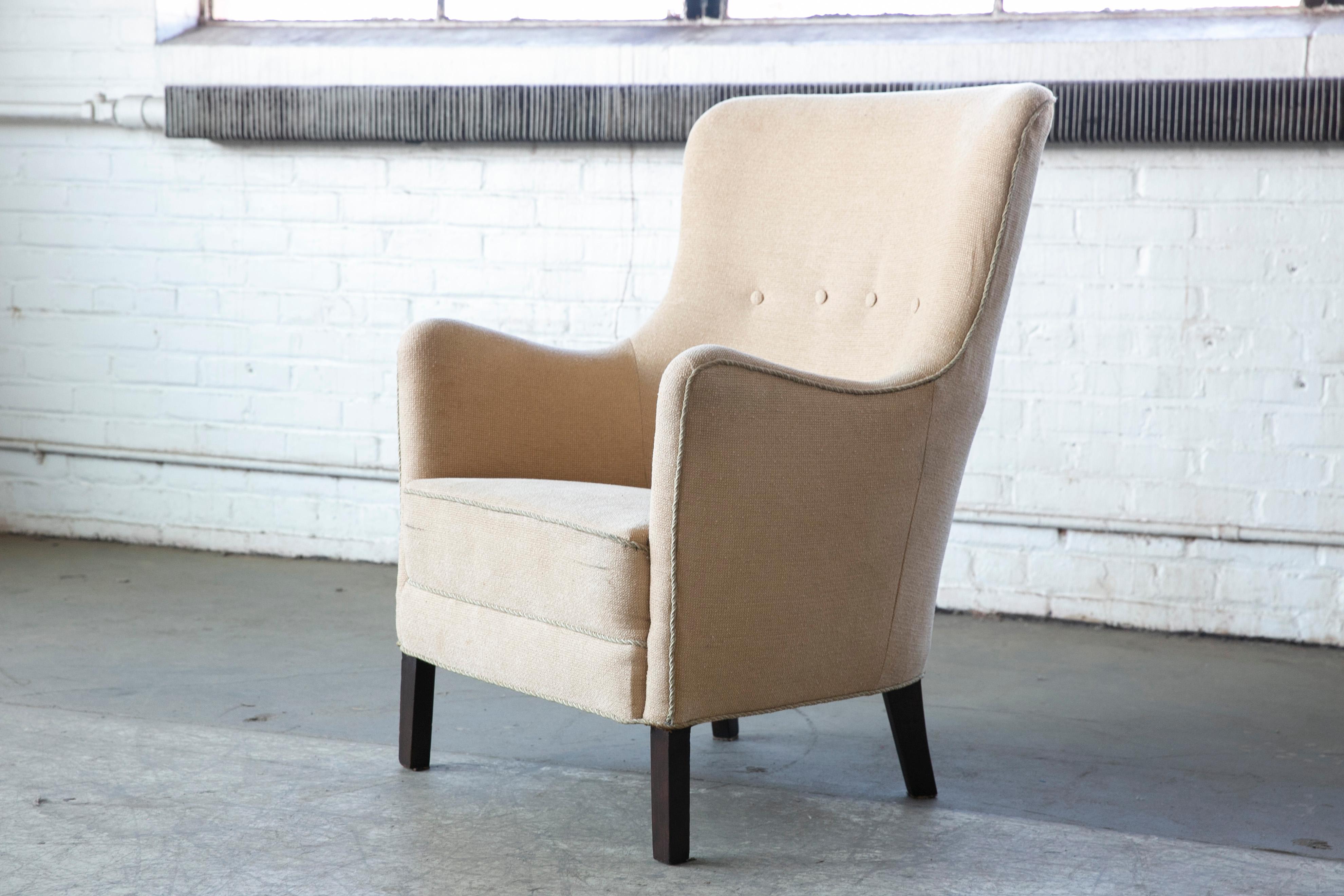 Elegant 1950s lounge chair attributed to Peter Hvidt and Orla Molgaard made in Denmark around 1950. Comfortable and sturdy re-upholstered at a later point, however showing just minor wear and remains in usable condition. Raised on beech legs. Some