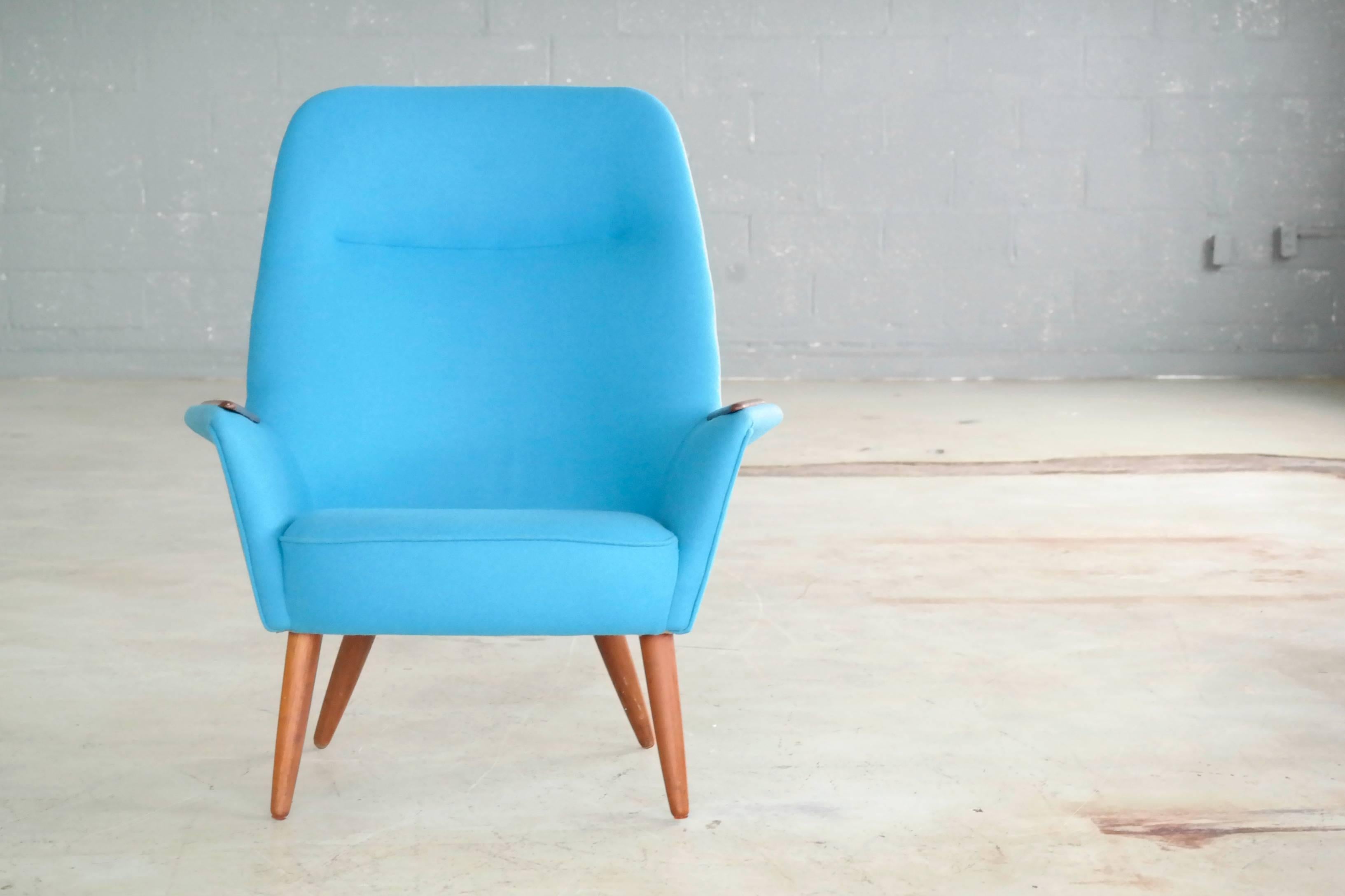 Elegant and very sweet Danish midcentury lounge chair made in the mid-1950s presumably designed by Frode Holm. Fully refurbished and newly re-upholstered in a smooth light blue Divino wool made by Kvadrat of Denmark. Strong statement piece despite
