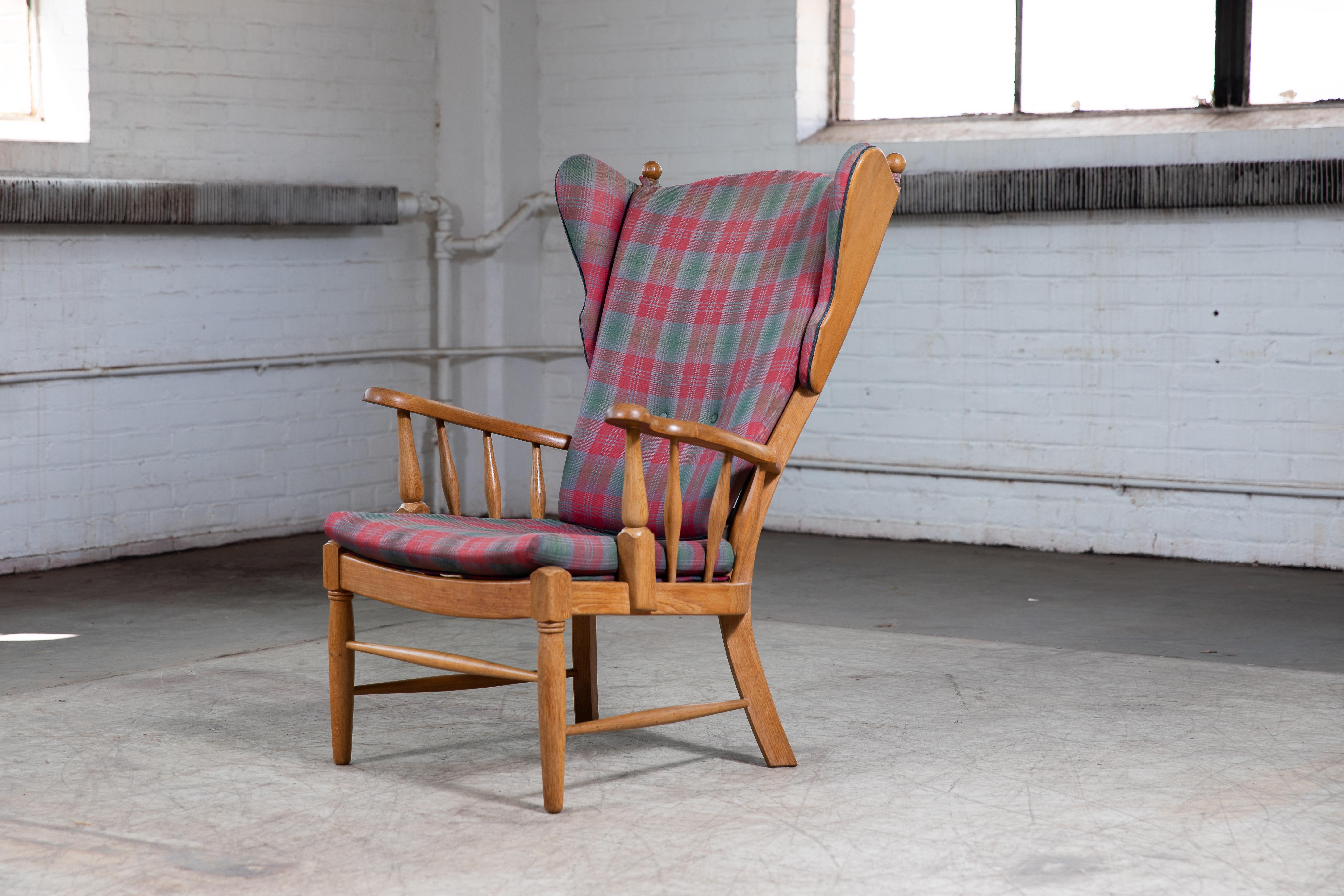 Great example Danish midcentury counbtry-style design, circa 1950s wingback chair in carved solid oak with exposed sides. Sturdy and strong construction of generous proportions making for a very comfortable chair. Fantastic addition to the country