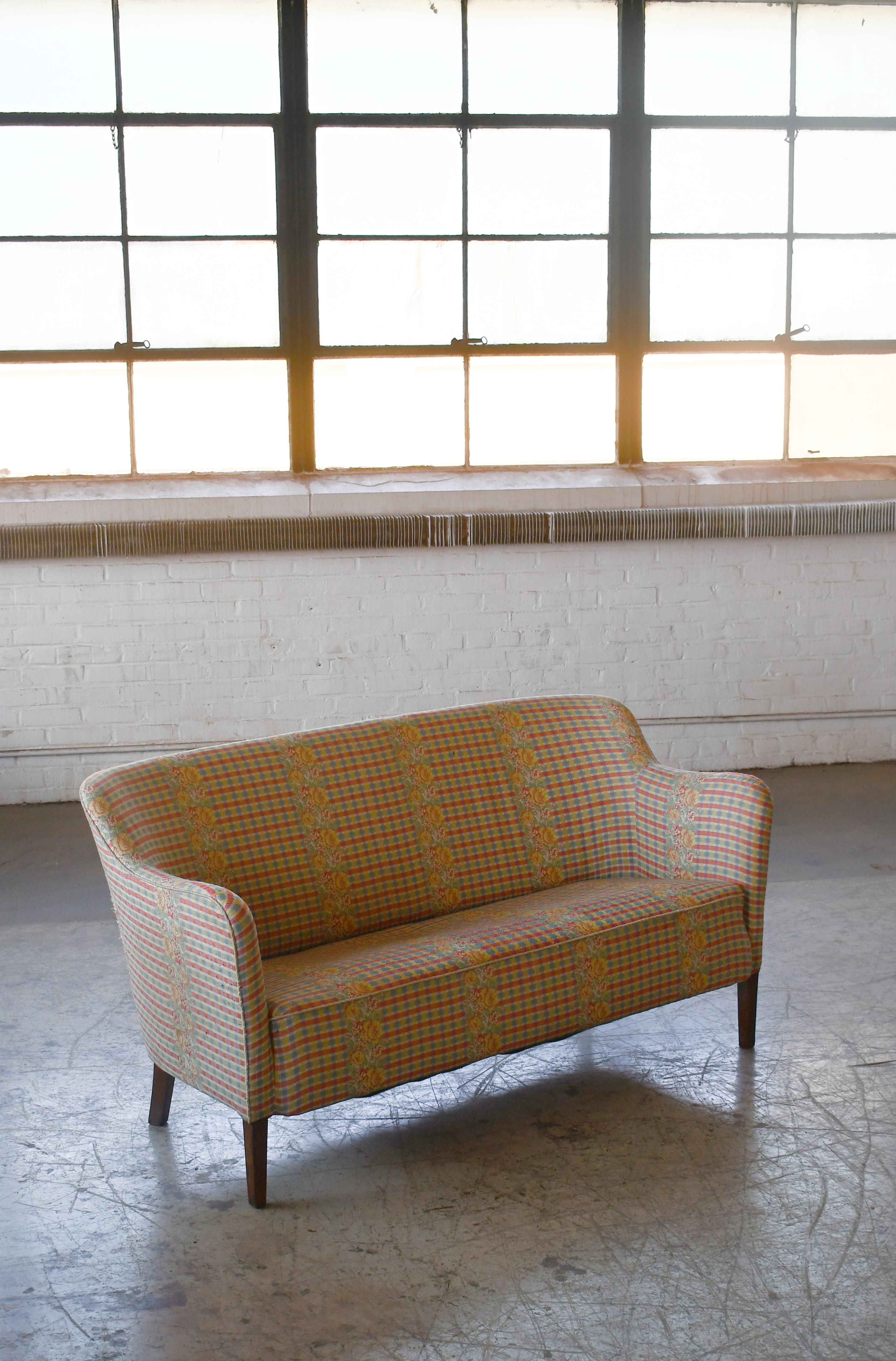 Klassische und sehr elegante Linien, ganz im Stil des frühen dänischen Designers Peter Hvidt aus den späten 1940er bis 1950er Jahren. Rückenlehne und Sitz sind schön fest und der Rahmen auf den kubanischen Mahagonibeinen bleibt stabil. Das Sofa