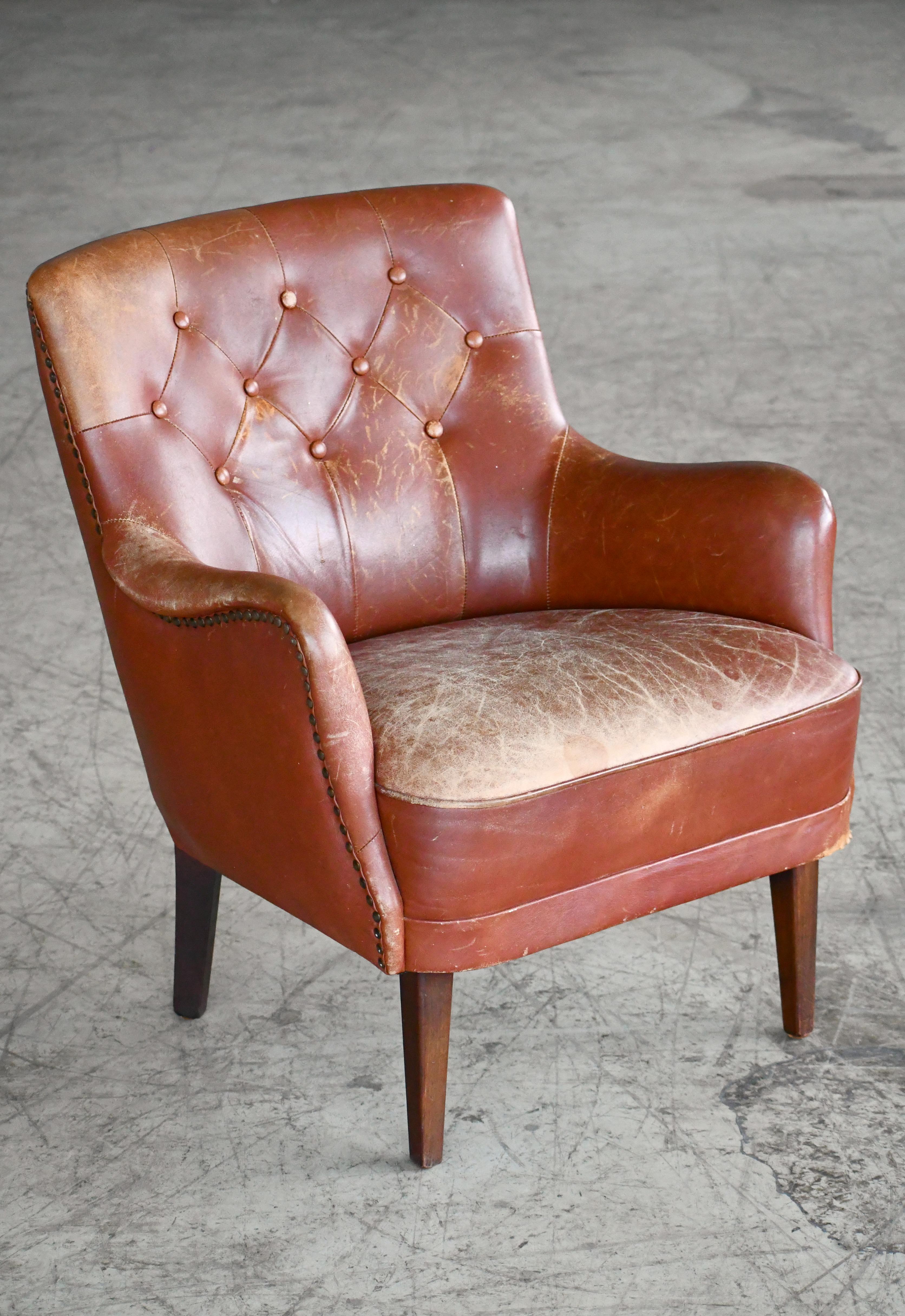 Charming and elegant small Danish easy chair in the style of Frits Henningsen with tufted leather back. Leather is in good condition with a nice patina and some wear on the seat and some scuffs and scrathes on the backrest and some surface wear to
