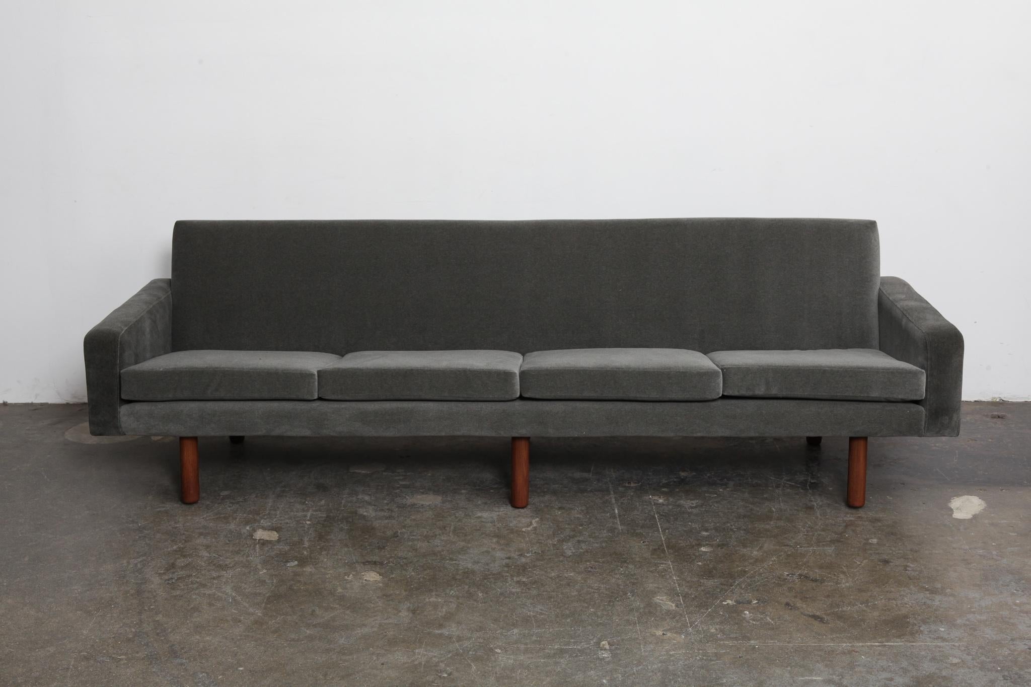 Danish 4-seat 1960s fabric sofa with 4 loose seat cushions and tight back style and straight clean lines throughout, sitting on 6 tapering solid teak legs (that have been refinished). Newly upholstered in a grey mohair/velvet fabric, teak legs