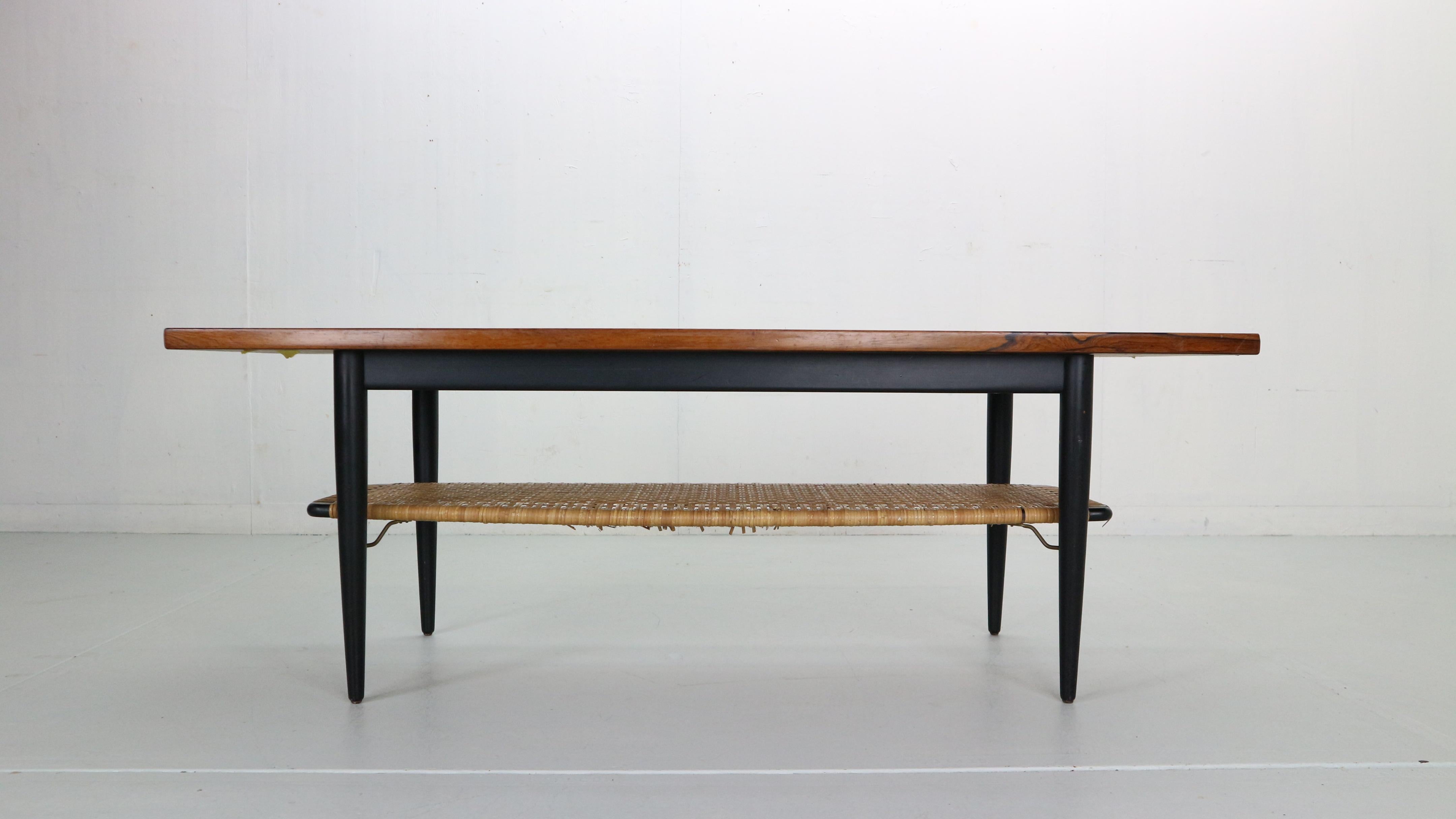 Mid-Century Modern Danish design coffee table from the 1960s. 
The table has organic shaped lines and is made from brazilian rosewood. Beautiful wood patina and very good condition. Has a small magazine/ book shelve under the table made of woven