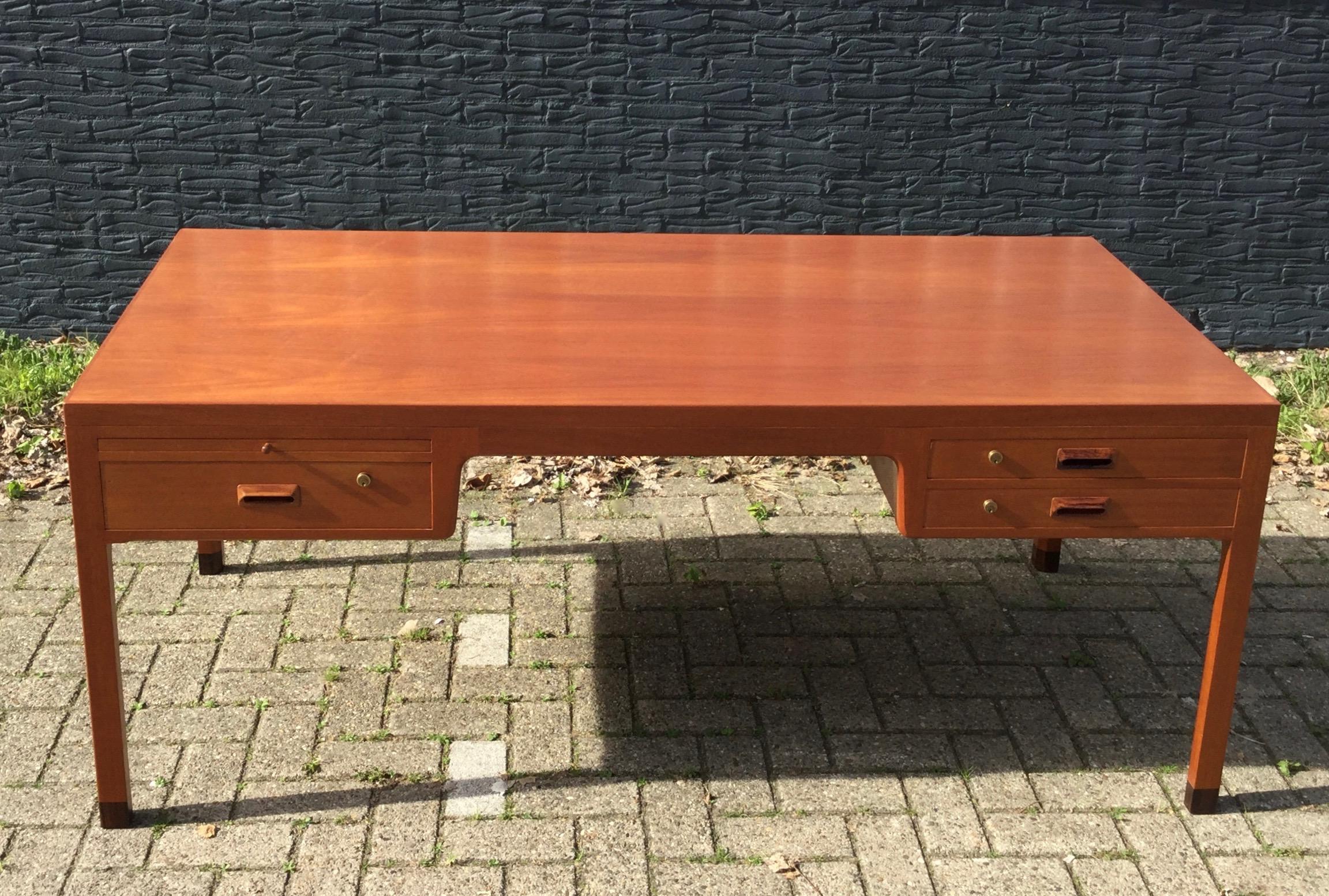 Exceptional high quality crafted Danish desk by Aksel Bender Madsen & Ejner Larsen from the mid 1960s. The desk is executed in mahogany (looks like teak) with beautiful details, amongst: one pull out tray with glass top (last picture) to be found
