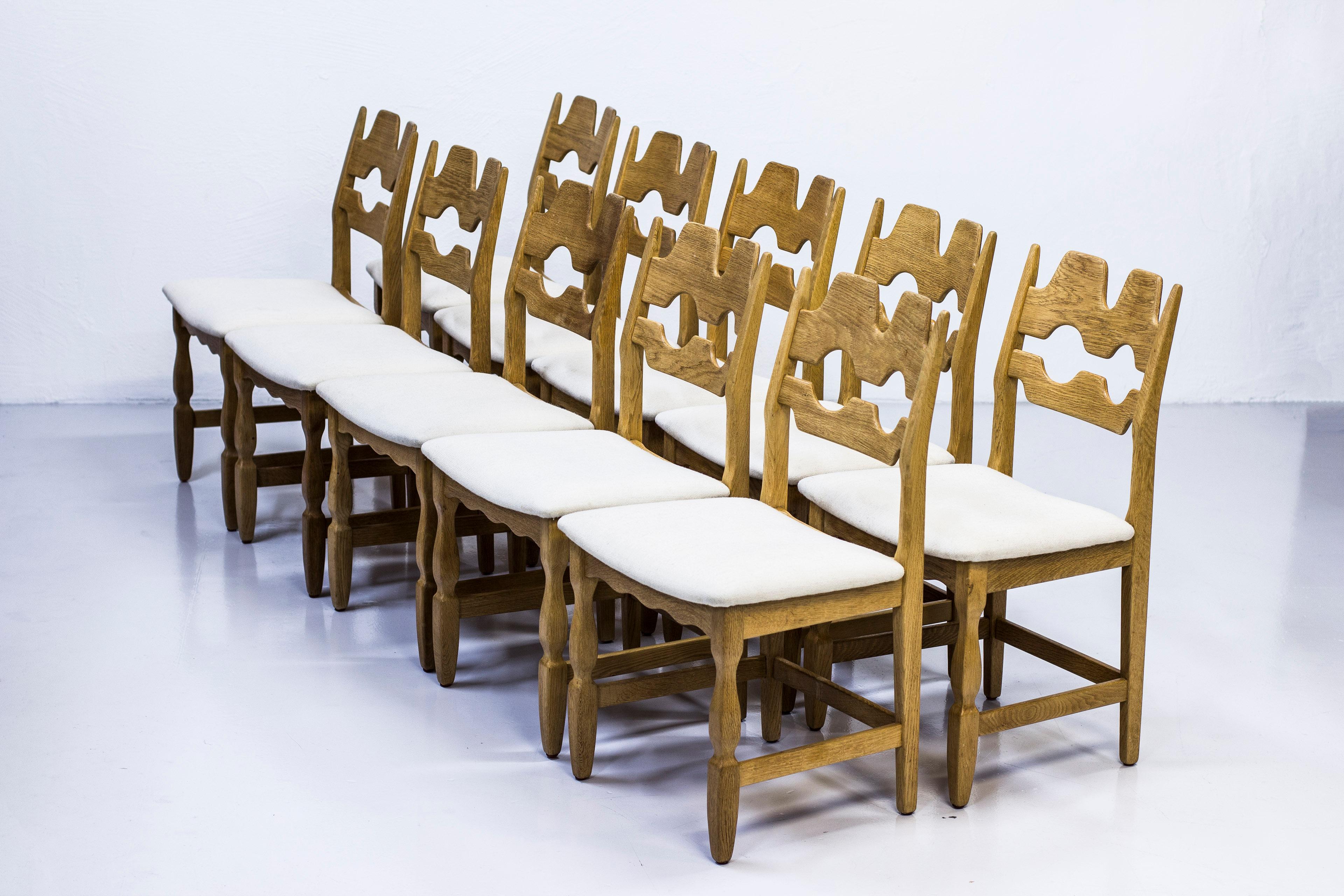 Set of ten dining chairs designed by Henning Kjærnulf. Produced in Denmark during the 1960s by EG Møbler. Made from solid oak with off white wool fabric seats. Very good vintage condition with fews signs of wear and light age related