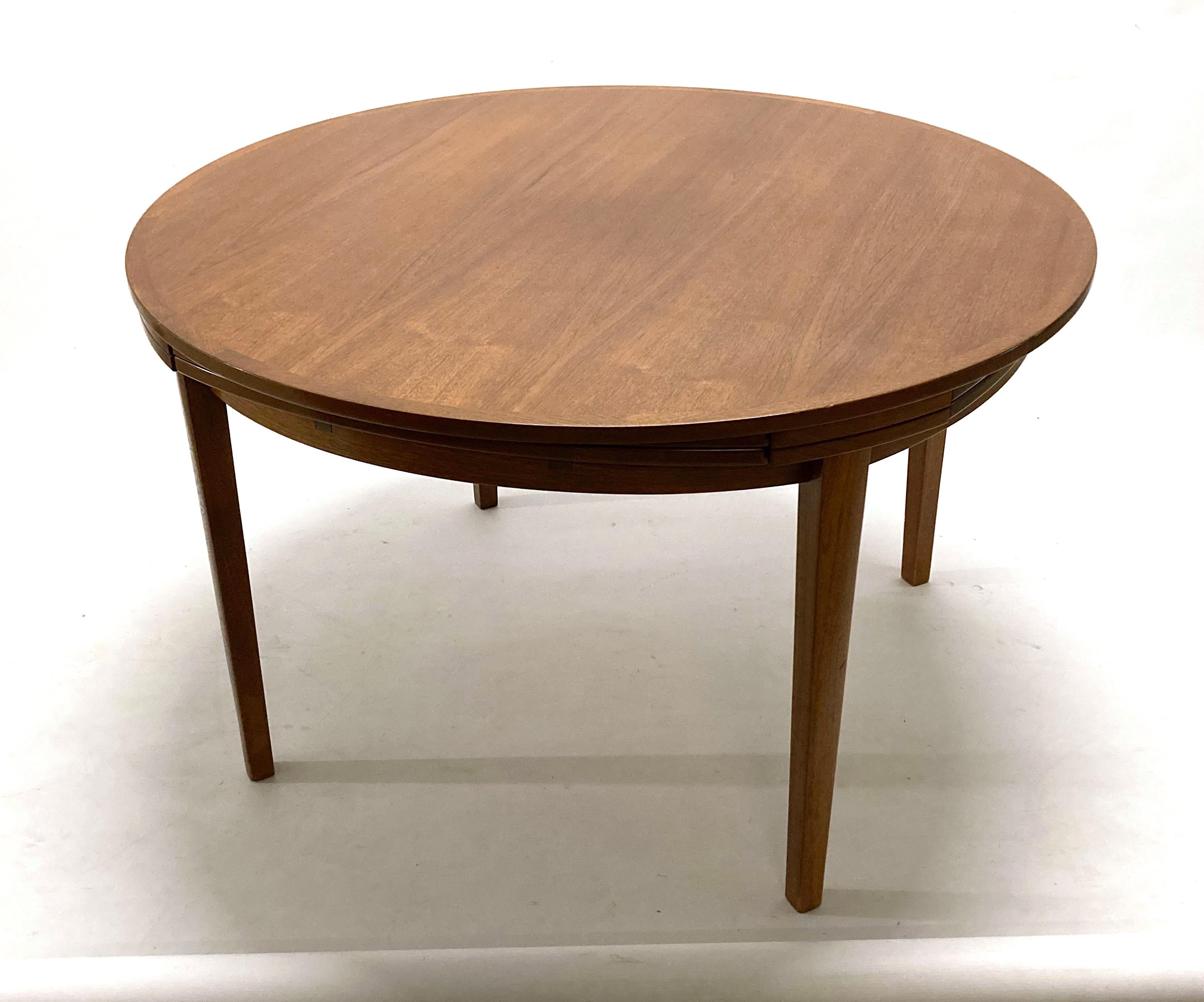 Danish Dyrlund teak Flip Flap Lotus dining table, circa 1965. With solid teak edge banding.

This table sits 4 comfortably for everyday use, and 8 when extended. There are 4 pull out folding leaves that fit under the table and slide out and flip