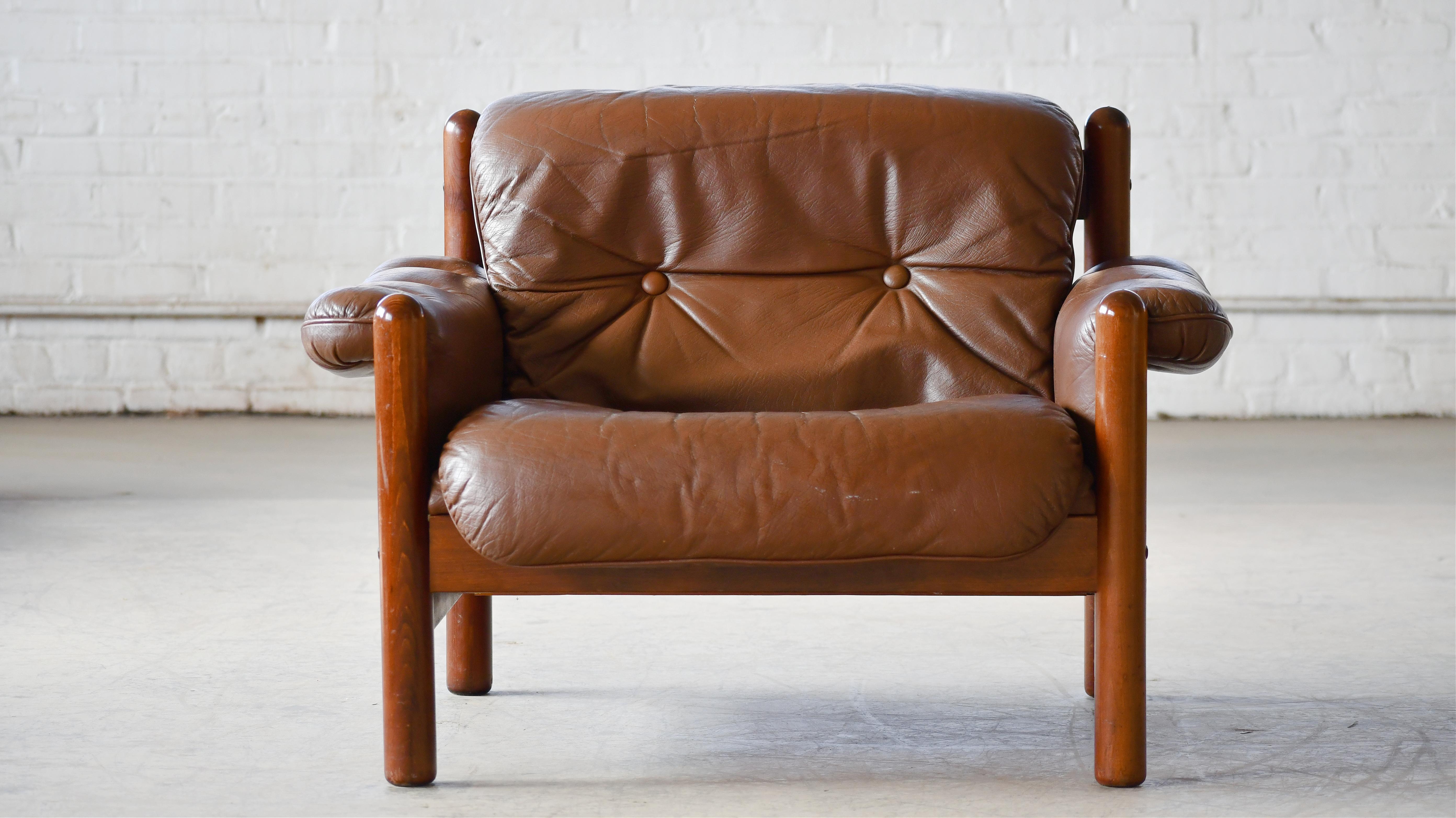 Low Danish easy chair with brown leather cushions and rosewood stained beechwood frame. In the style of Kristian Vedel and Bruno Mathsson among other that made the this relaxed style famous in the 1960's and 70's. Some sun fading of the frame but