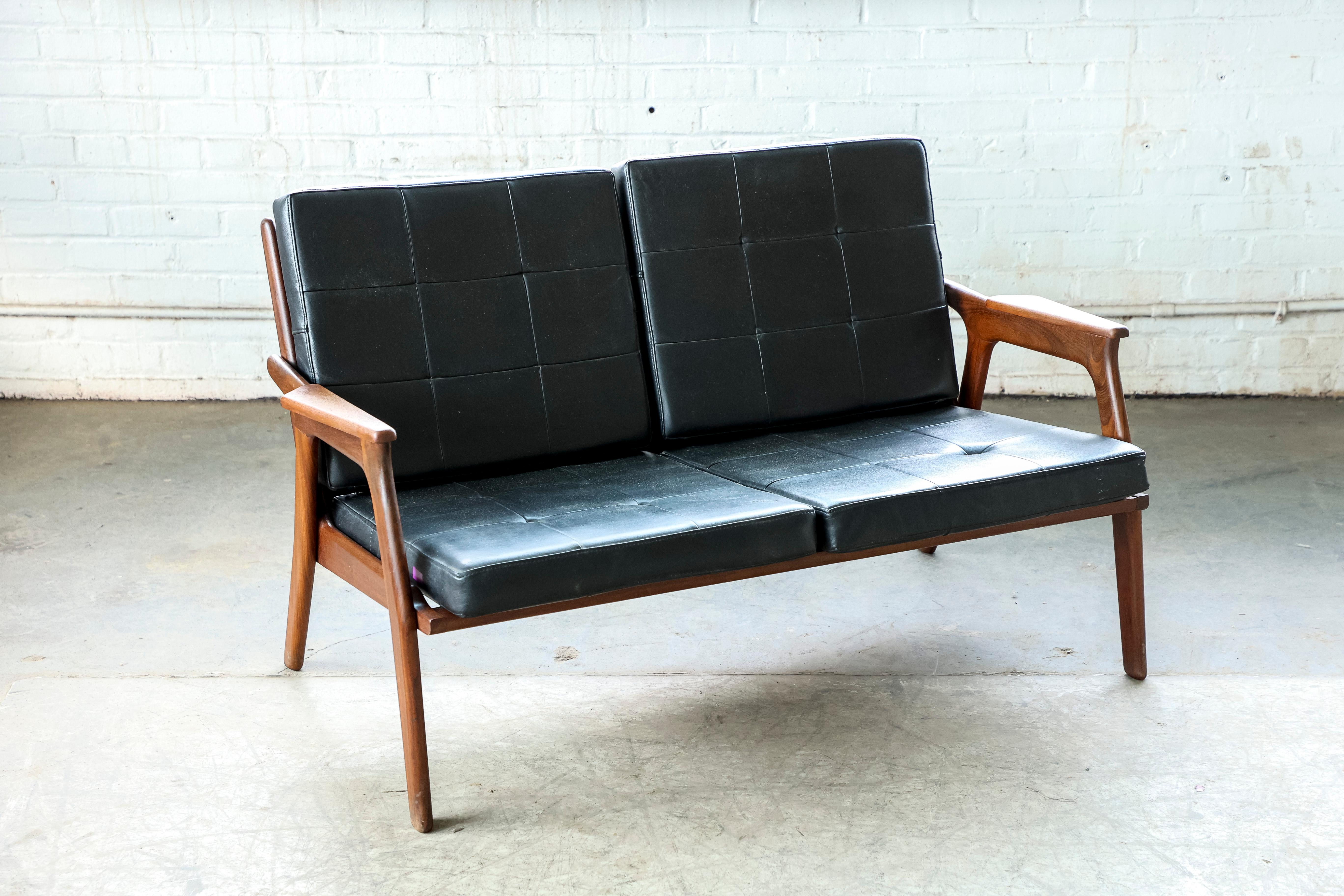 Beautiful and elegant small 1950s easy style Danish settee with the frame, legs and armrests in solid teak. Very high design quality and workmanship. The piece is unmarked but the design is almost identical to settees made by Tove and Edvard Kindt