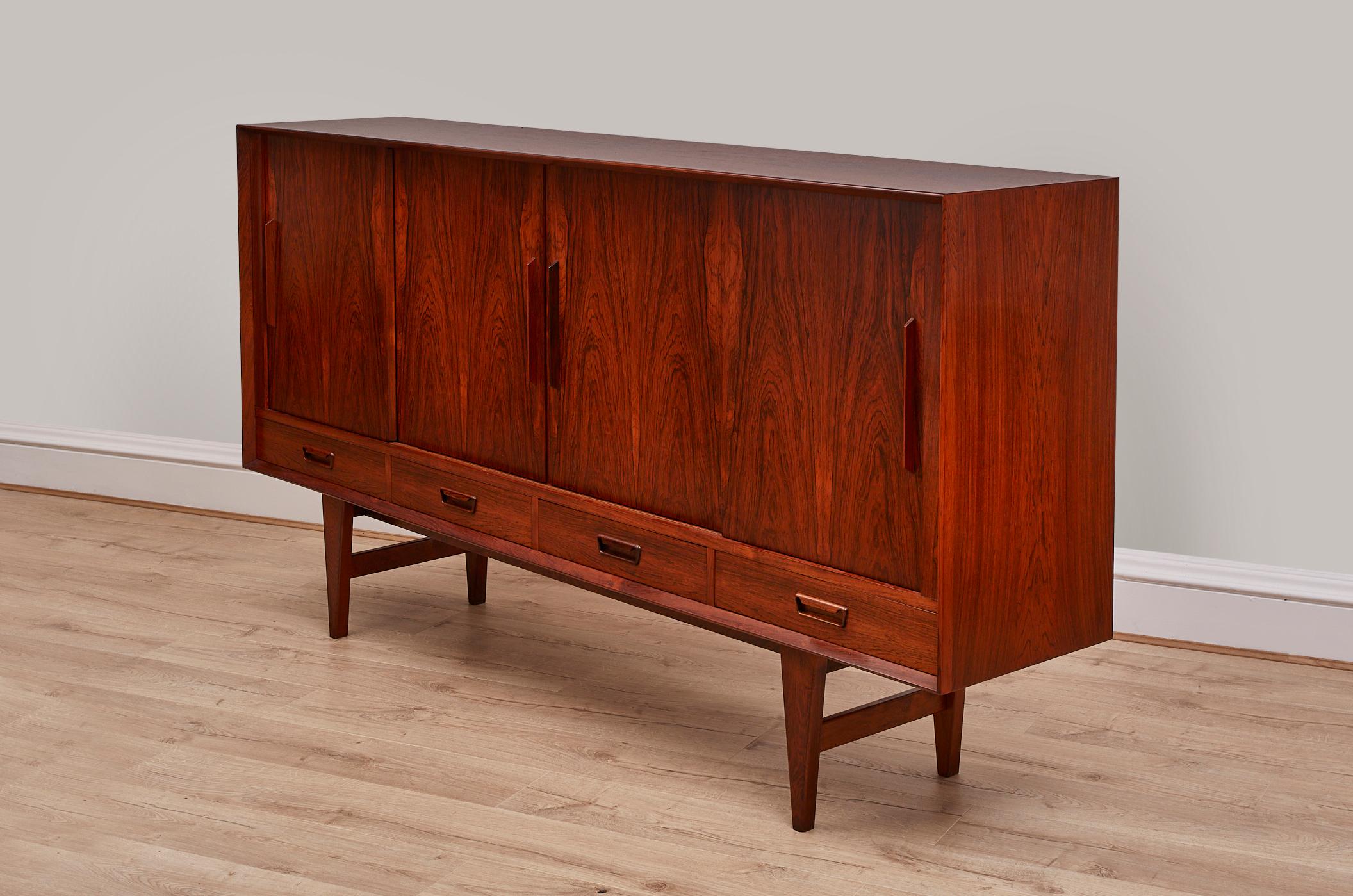 Step back in time with this exquisite 1960s Danish sideboard, a true icon of mid-century design. Crafted with precision and a keen eye for style, this sideboard boasts a timeless elegance that will elevate any space. It features four spacious bottom