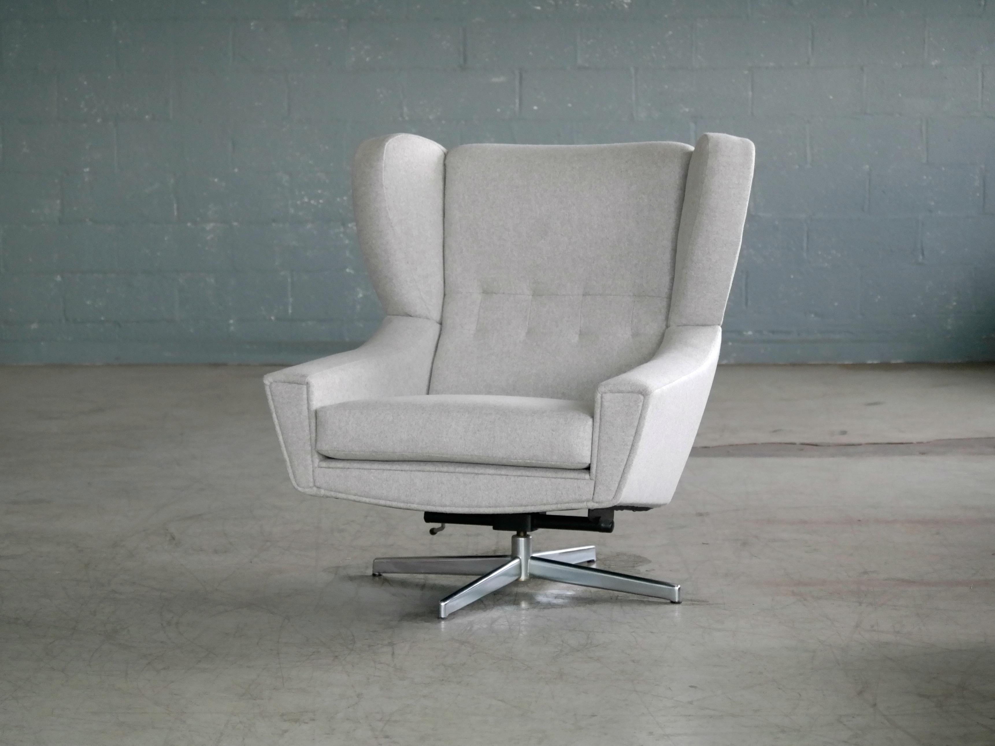 Exciting and very cool Space Age swivel chair attributed to Designer, Illum Wikkelso for Nielaus Jeki Mobler. Made in the latter part of 1960s it features a beautifully rather exuberant and very comfortable wing back design on an aluminum swivel