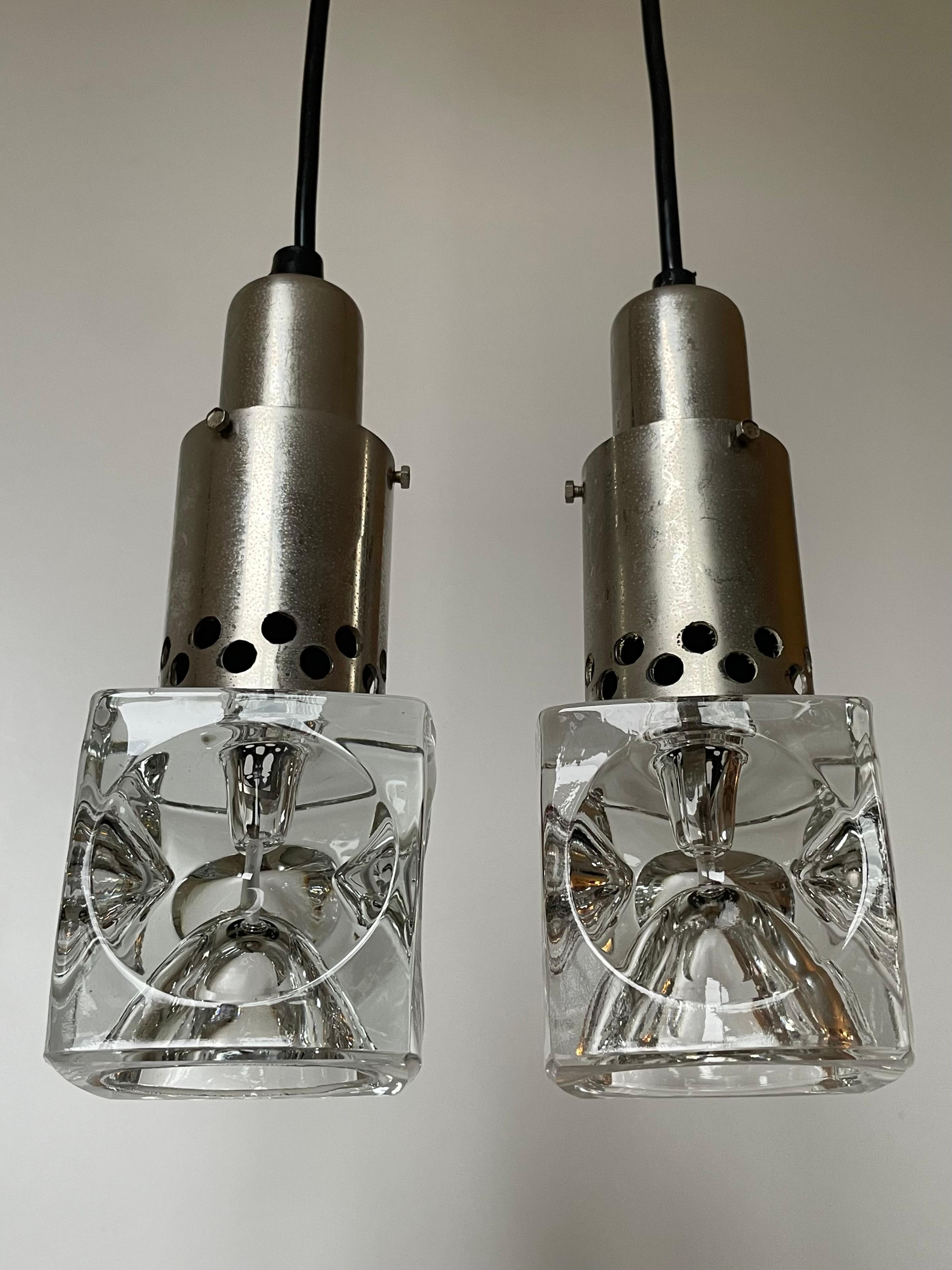 Set of two Scandinavian midcentury modern ceiling lights. Square shaped solid clear art glass with circular indentations mounted on cylinder chrome metal mount. Beautiful vintage condition. 
Denmark, 1960s.