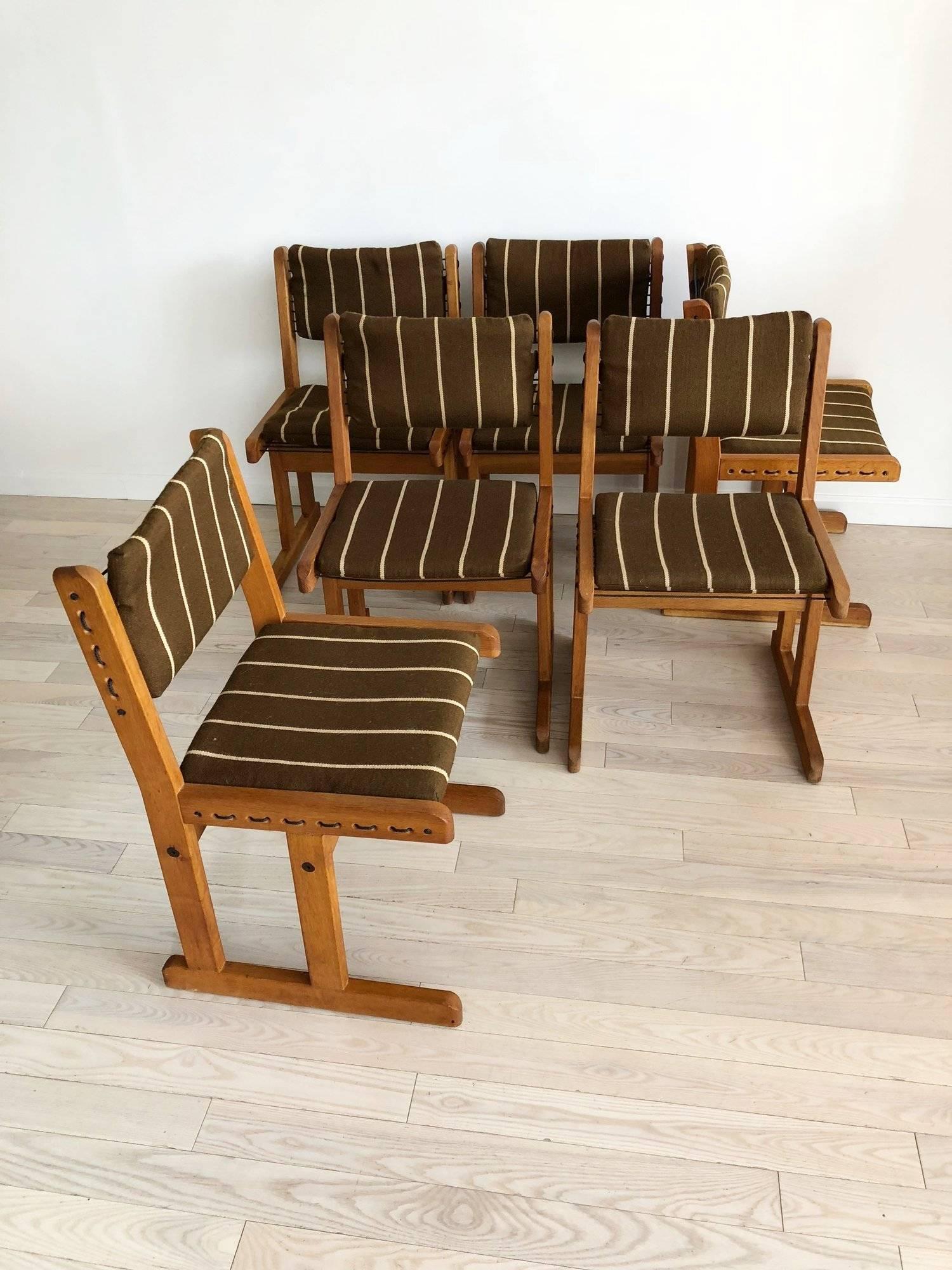 Set of six 1970s Danish dining chairs. Fumed oak with black rope cording. Removable brown wool striped cushions, leather attaches. Great profile! The chairs can be used with or without the cushions. 

Sold as a set of six only.