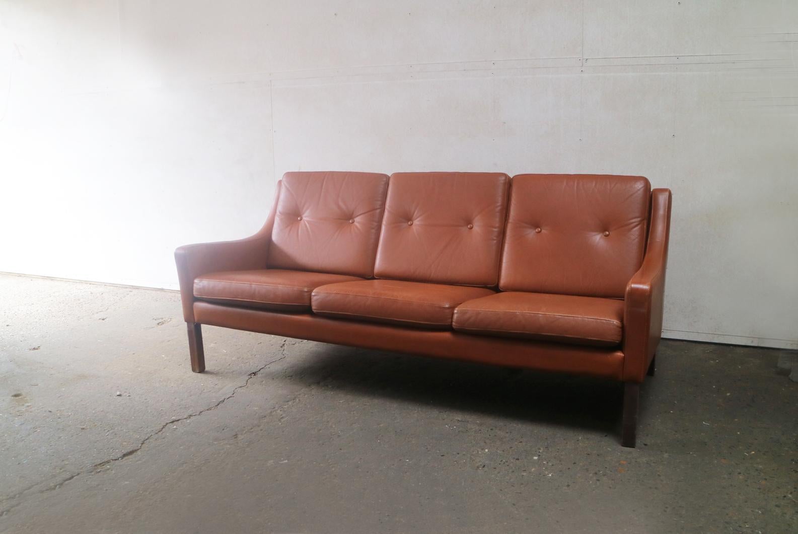Very handsome sofa design very similar to those of Danish designer Børge Mogensen. Upholstered in the original tan leather. Sits on stained beech legs.