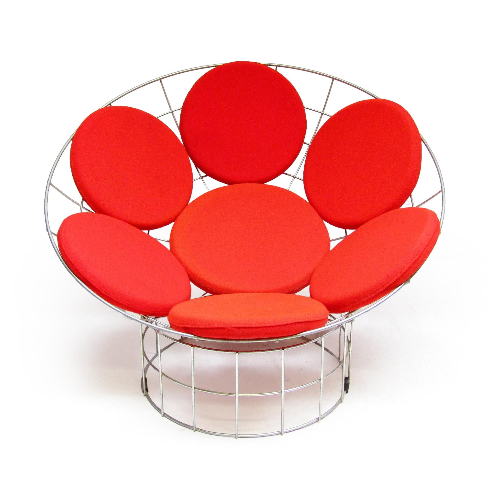 A visually striking and extremely comfortable lounge chair, Verner Panton's iconic design is comprised of steel basket form seat and cylindrical base with seven red seat pads. It can either be used in its complete form or the basket seat can be