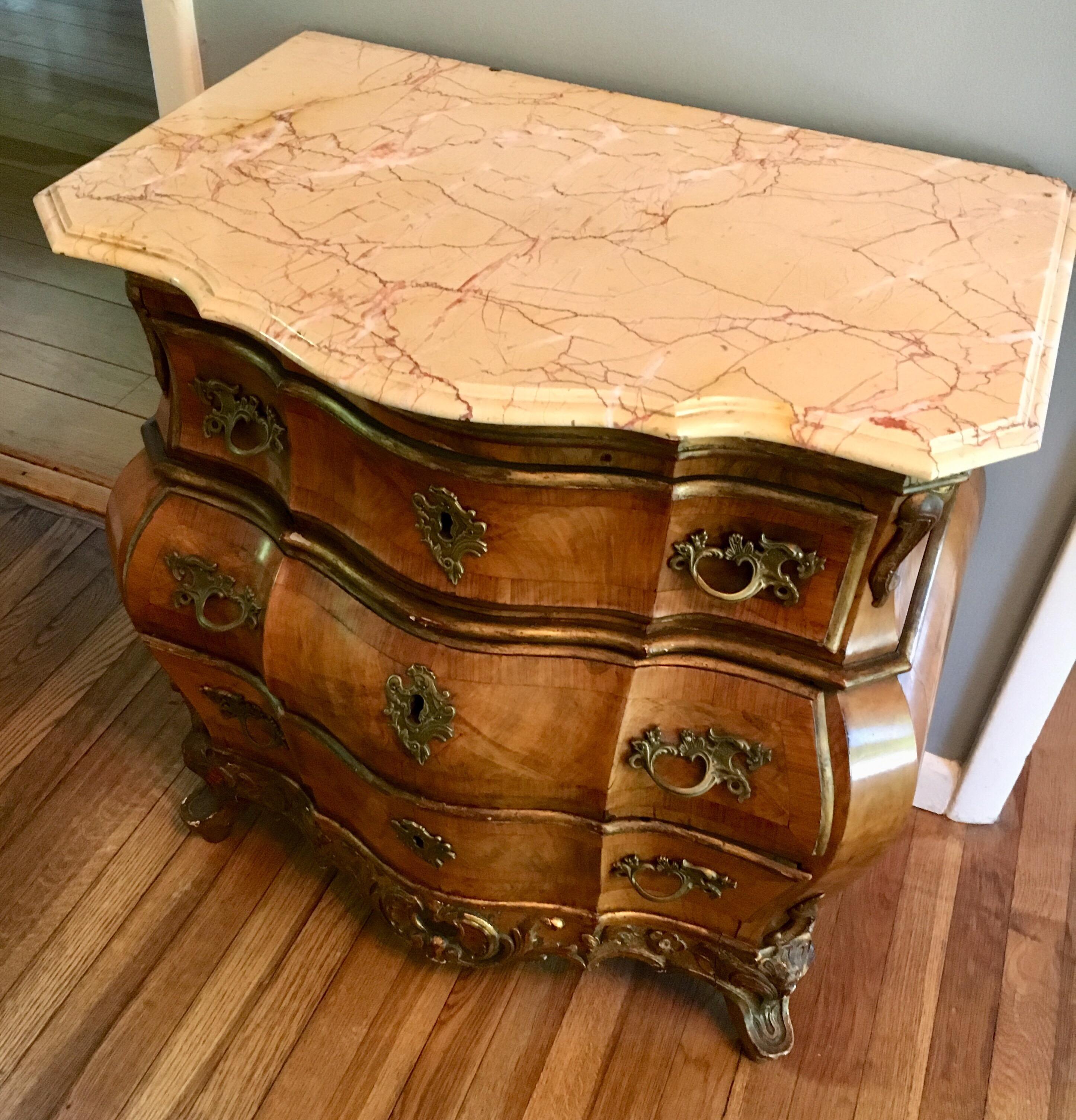 Gorgeous antique 19th century Danish 'Bombe' commode of walnut with parcel gilt carving. In the Rococo style of 18th century Royal furniture-maker Mathias Ortmann. Sumptuous detailing and lustrous patina. Pretty pink veined marble top (later date).