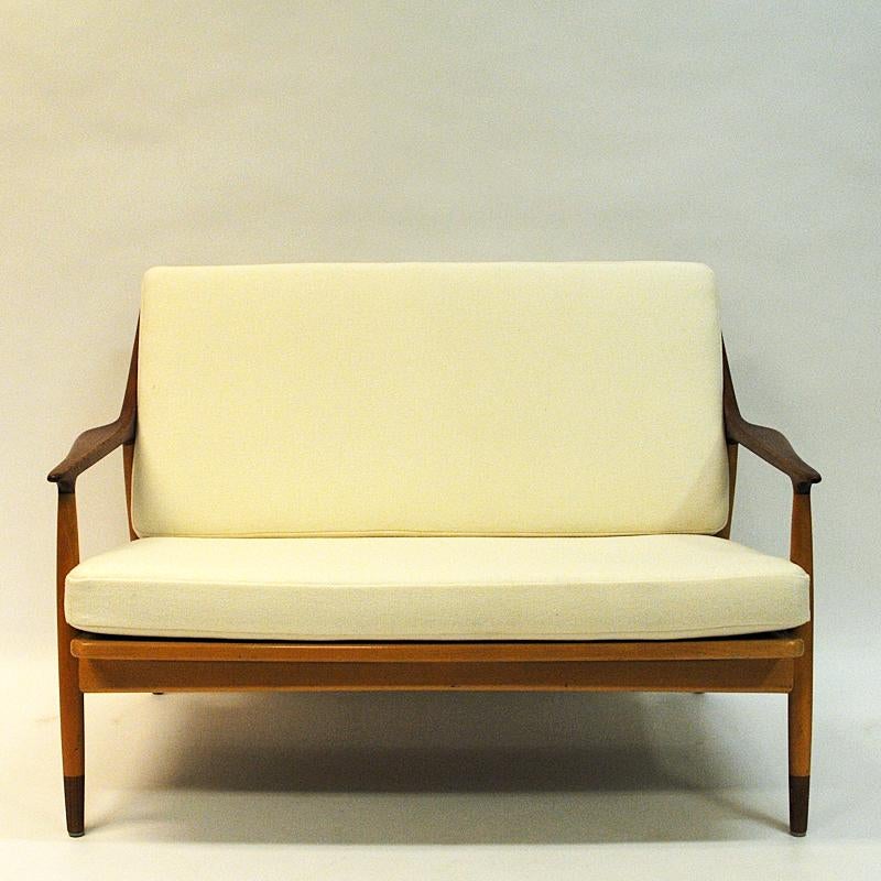 Danish Modern love seat newly upholsthered in a Norwegian cream white whool fabric named Amdal 100 from Gudbrandsdalen Uldvarefabrikk. This 2-seater sofa is designed by Kurt Østervig for Jason Møbler in Denmark 1950s, and has a solid beech wood