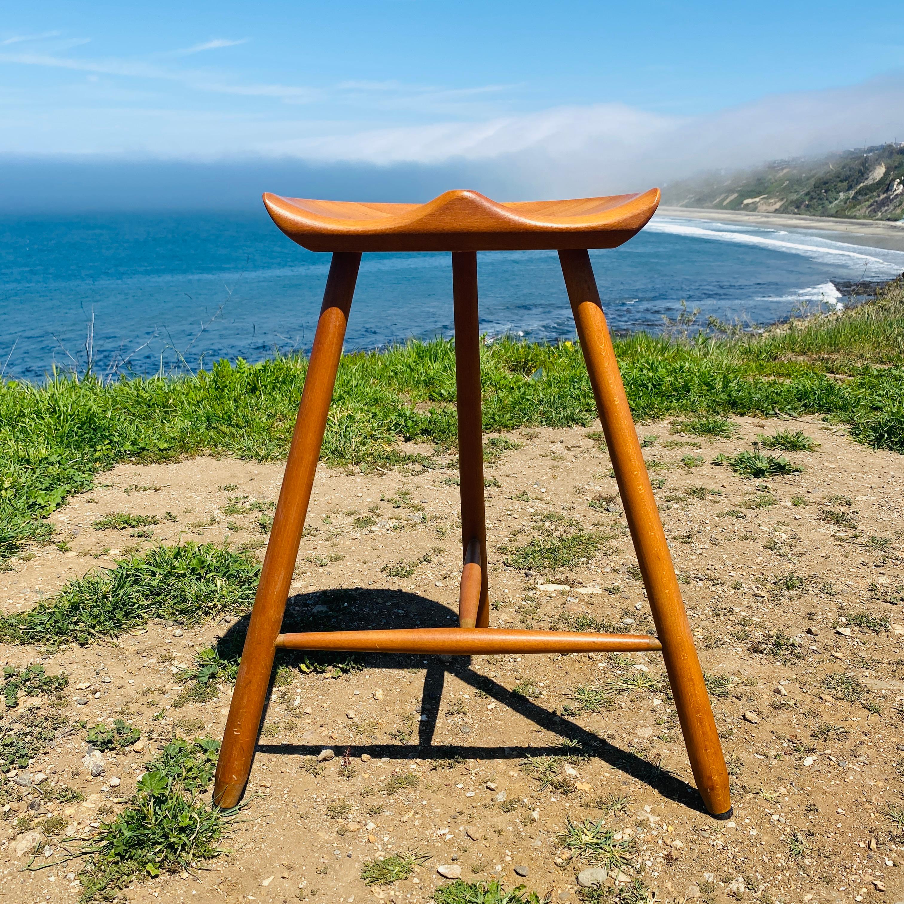 Questo splendido sgabello a tre gambe, di cui quello di Arne Hovmand-Olsen è il più famoso, è caratterizzato da uno stile rustico e snello. Lo sgabello è realizzato in faggio massiccio con una seduta scolpita in modo ergonomico e una base a