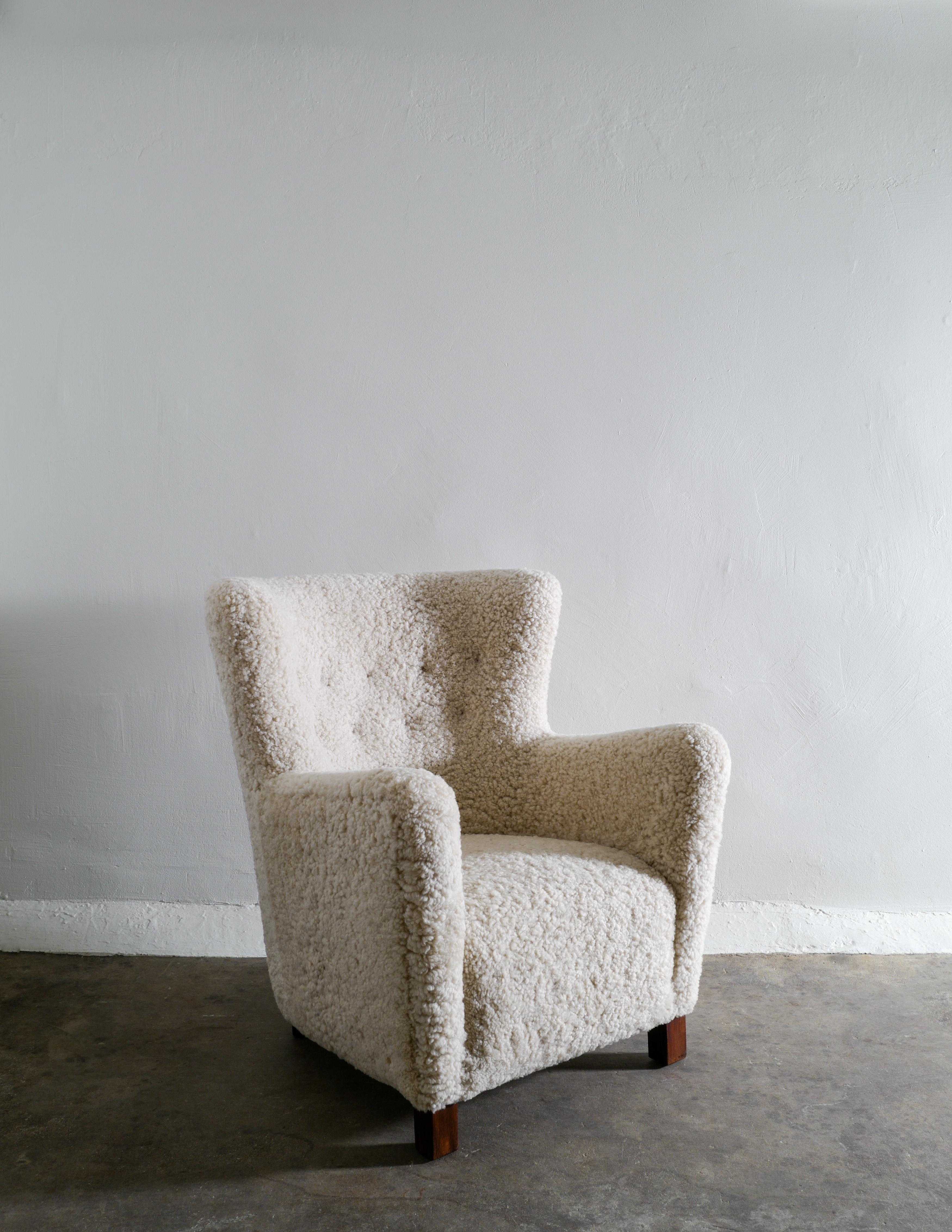 Rare 1940s danish armchair in sheepskin with oak feet in style of Fritz Hansen. Produced in Denmark and newly restored and upholstered in a neutral sheepskin. Excellent condition.